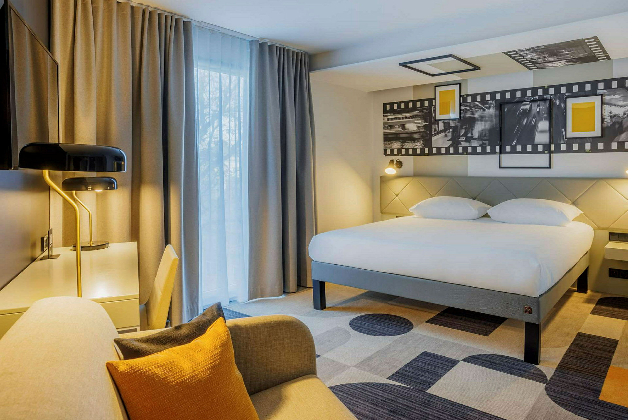 Hotellrum med stor säng, skrivbord och sittplats. (AI-genererad text)