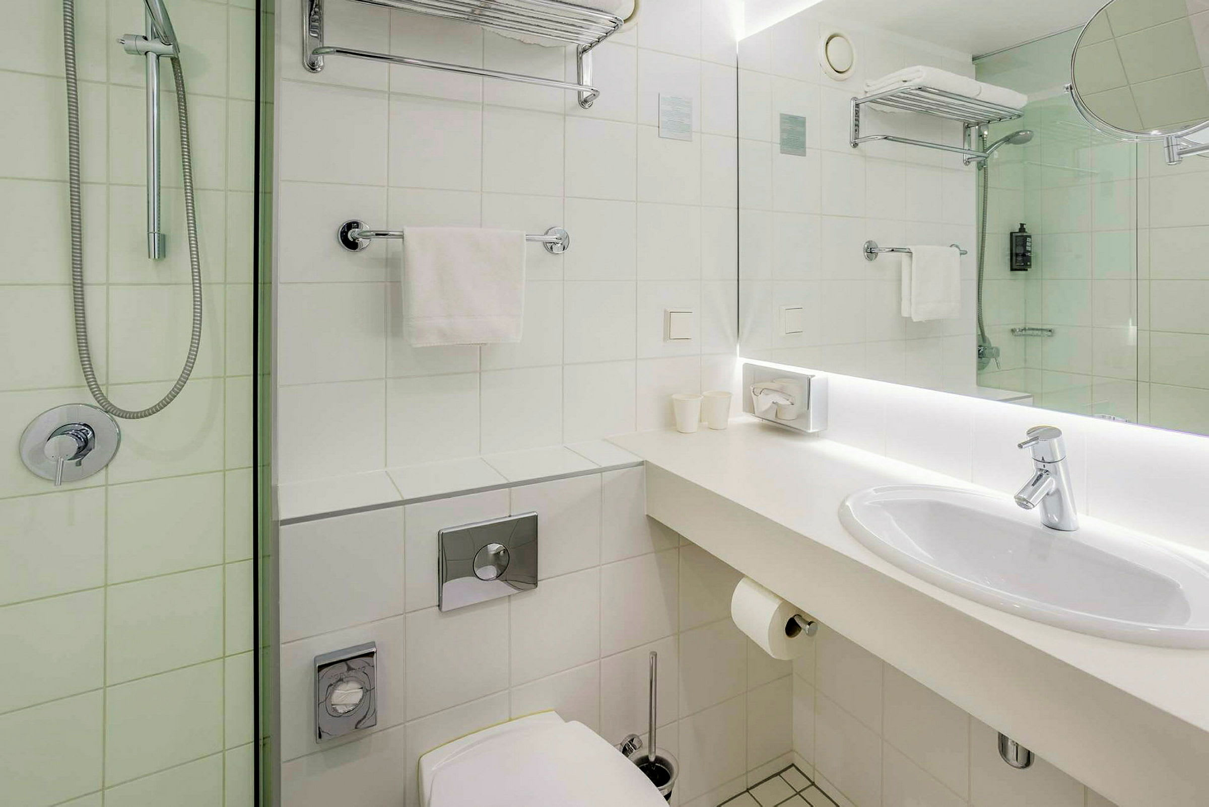 Badrum med vit design, handfat, och dusch. (AI-genererad text)