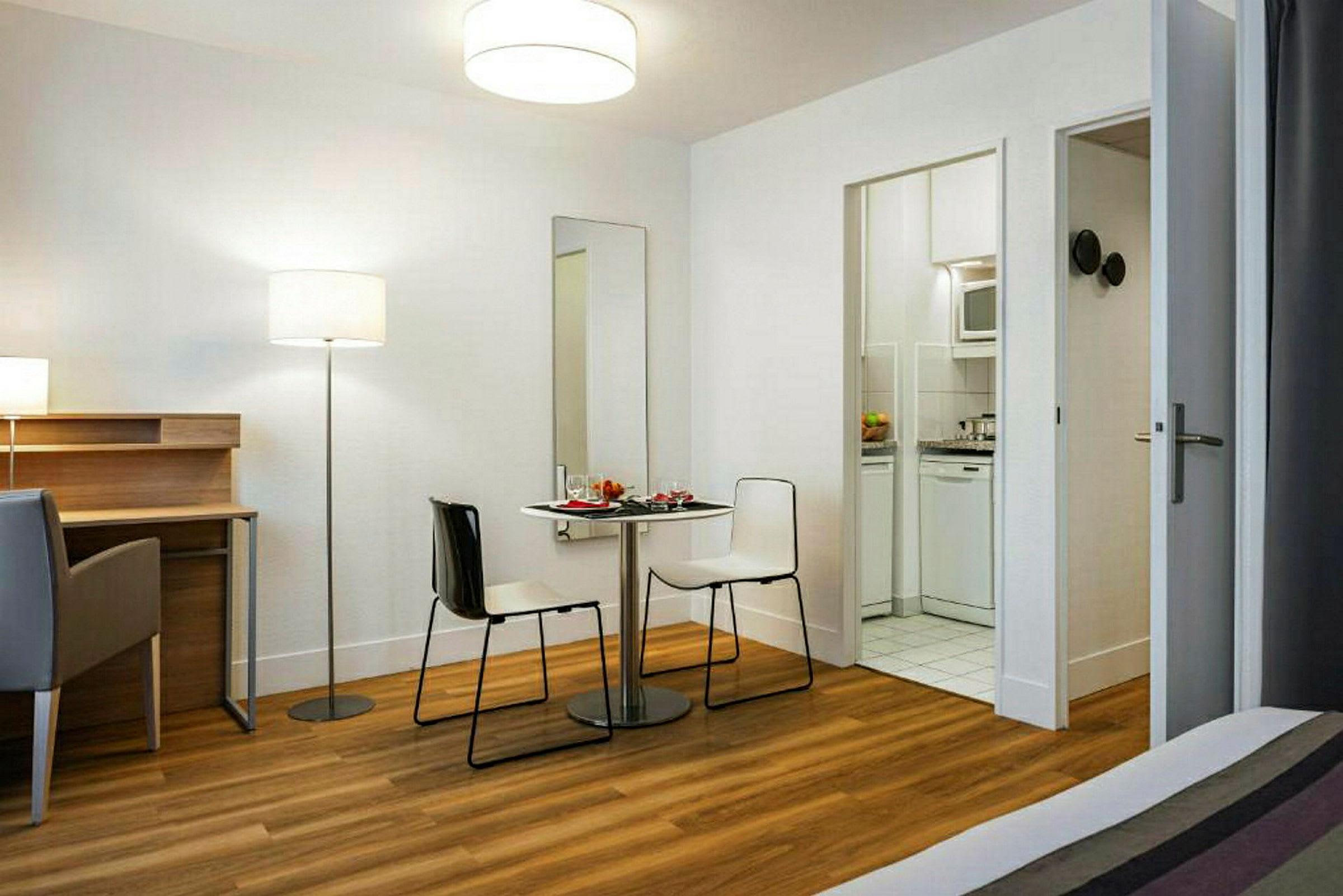 Inredning av ett hotellrum med en liten matplats och skrivbord. (AI-genererad text)