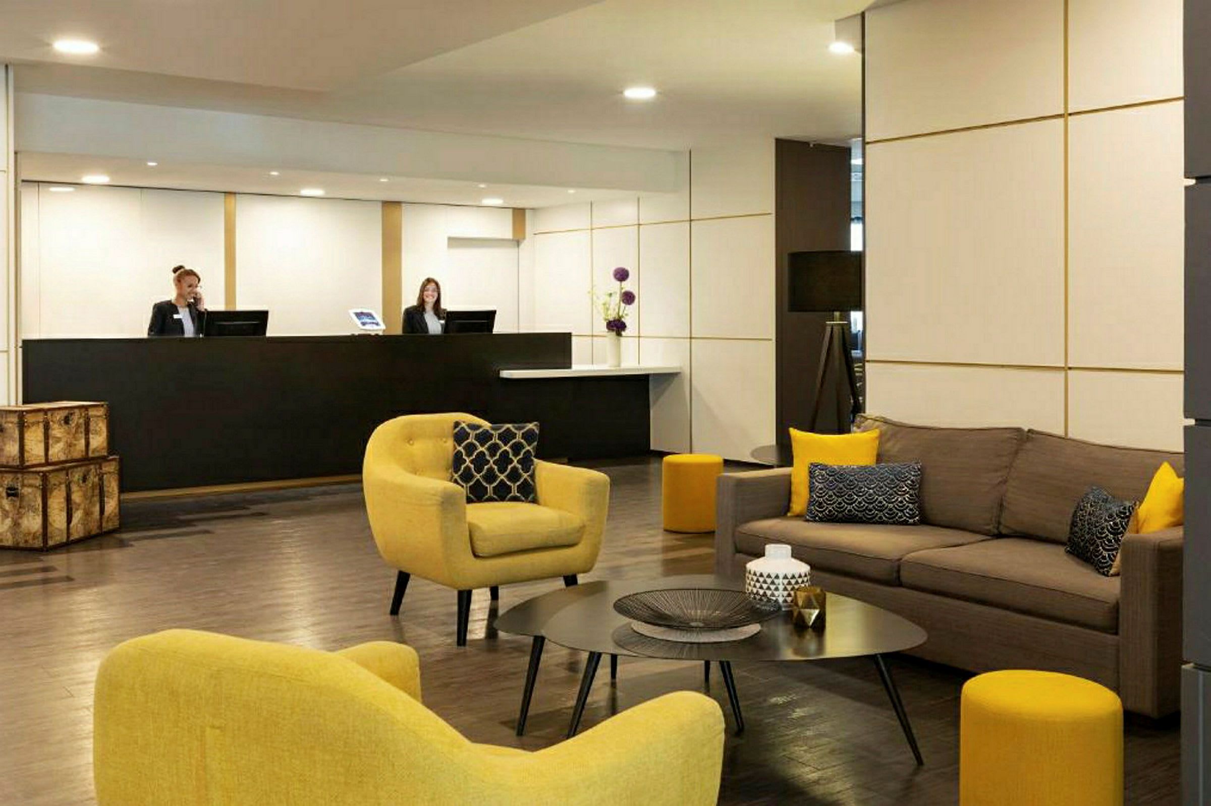 Ett hotellobby med soffor och fåtöljer samt ett receptionsområde. (AI-genererad text)