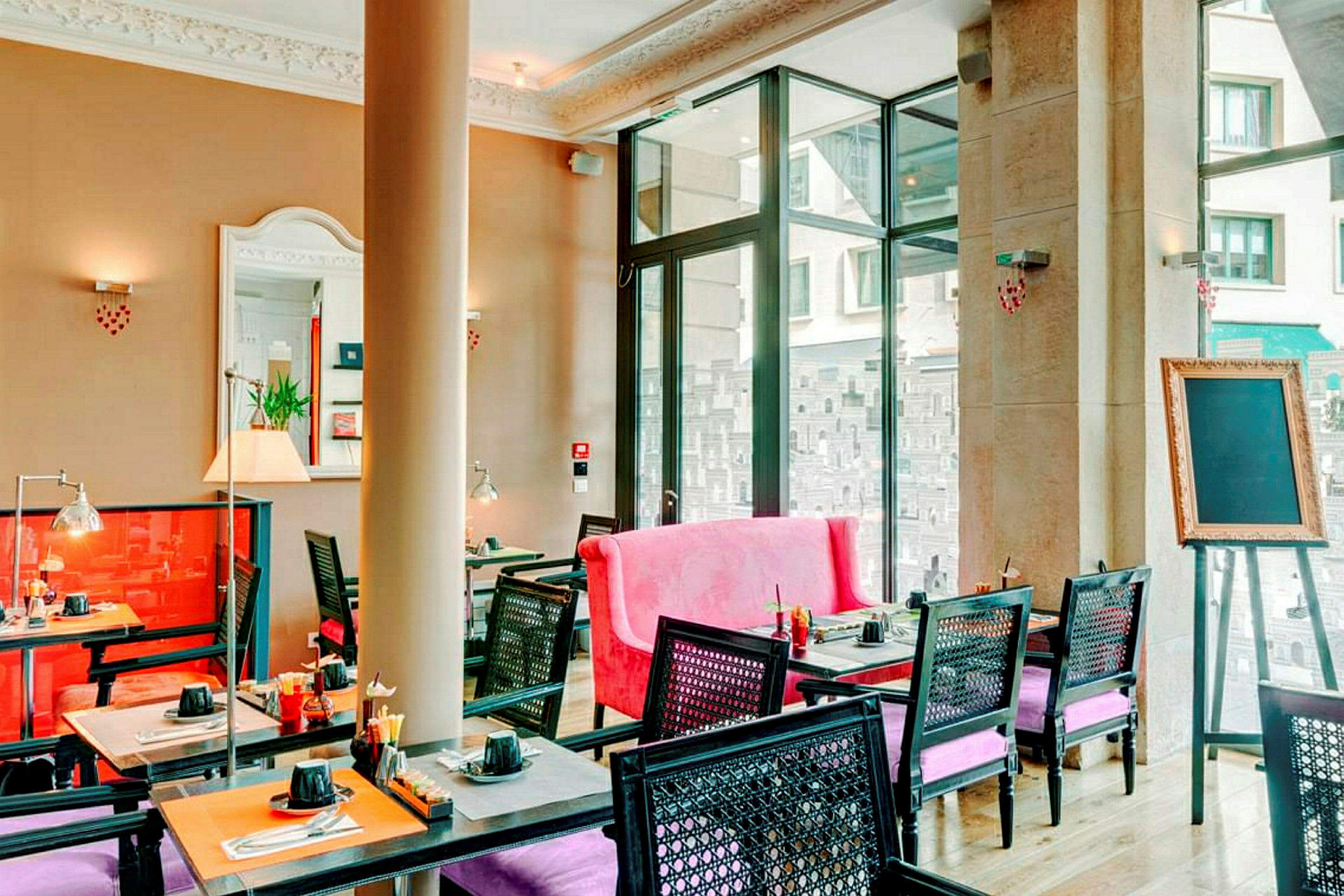 En bild av en elegant inredd restaurang med färgglada möbler och stora fönster. (AI-genererad text)