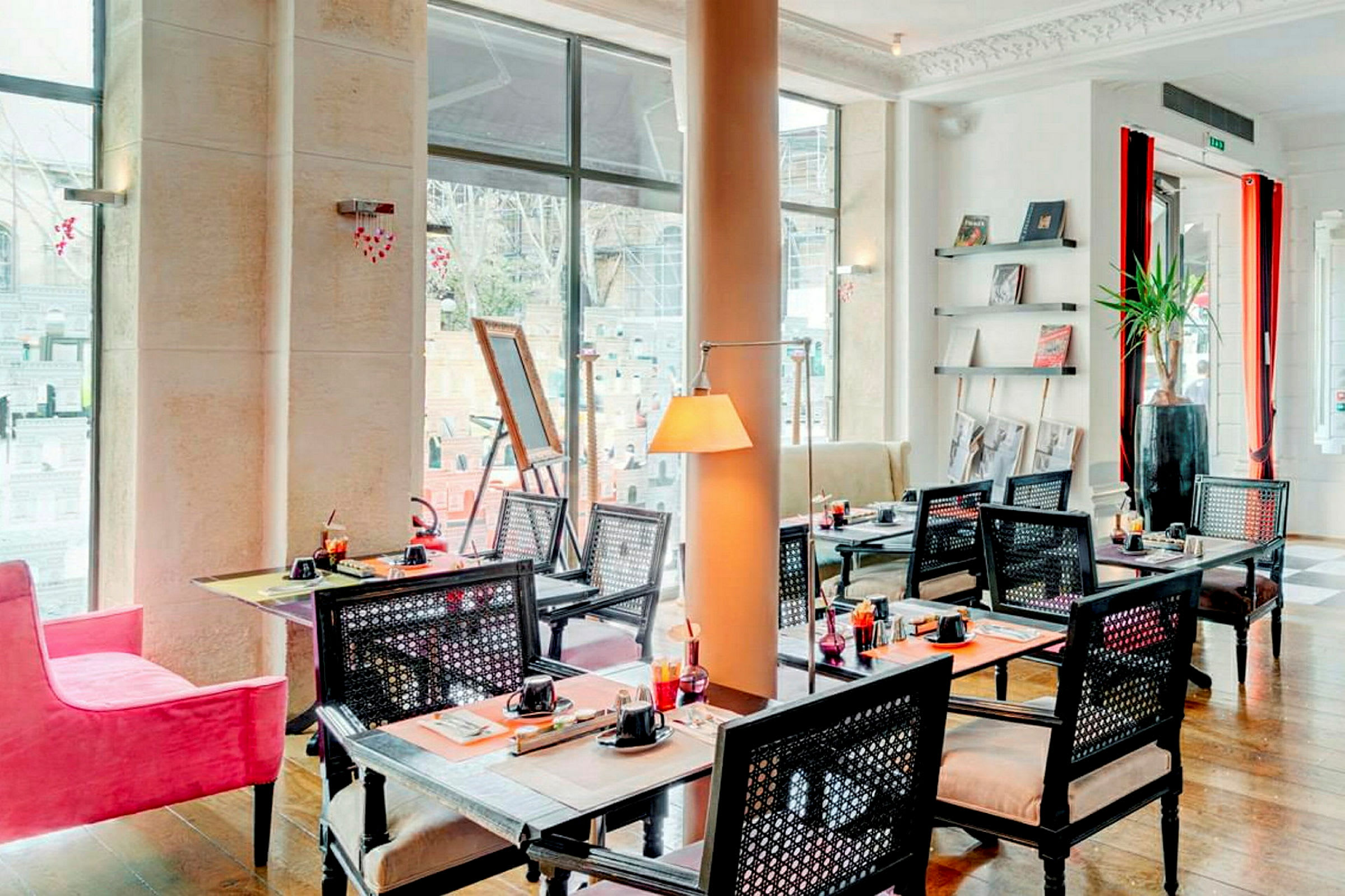 En restaurang med bord och stolar, dekorerad med konst och inredningsdetaljer. (AI-genererad text)