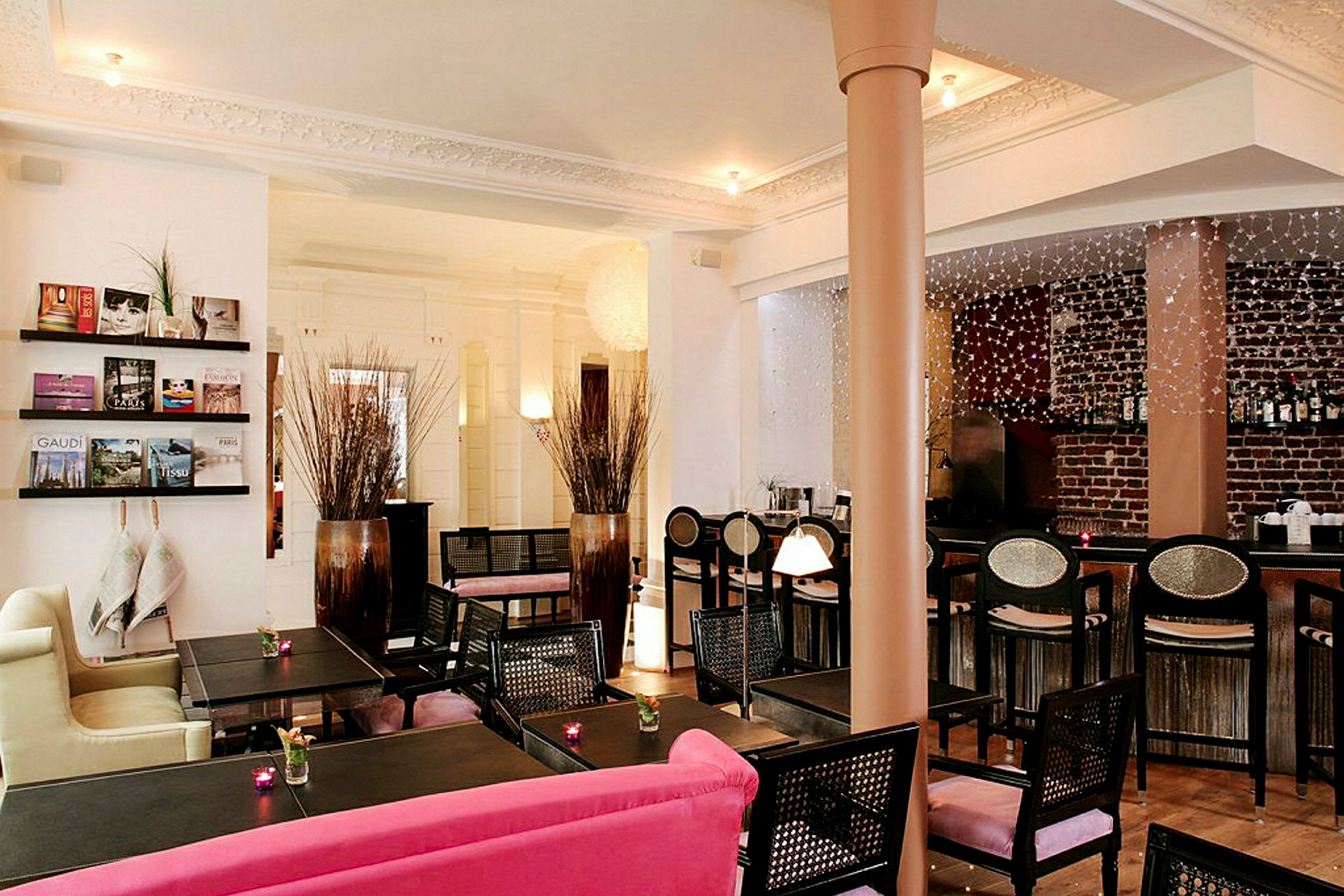 Ett inredd café- eller hotelllounge med bord, stolar och dekorationer. (AI-genererad text)