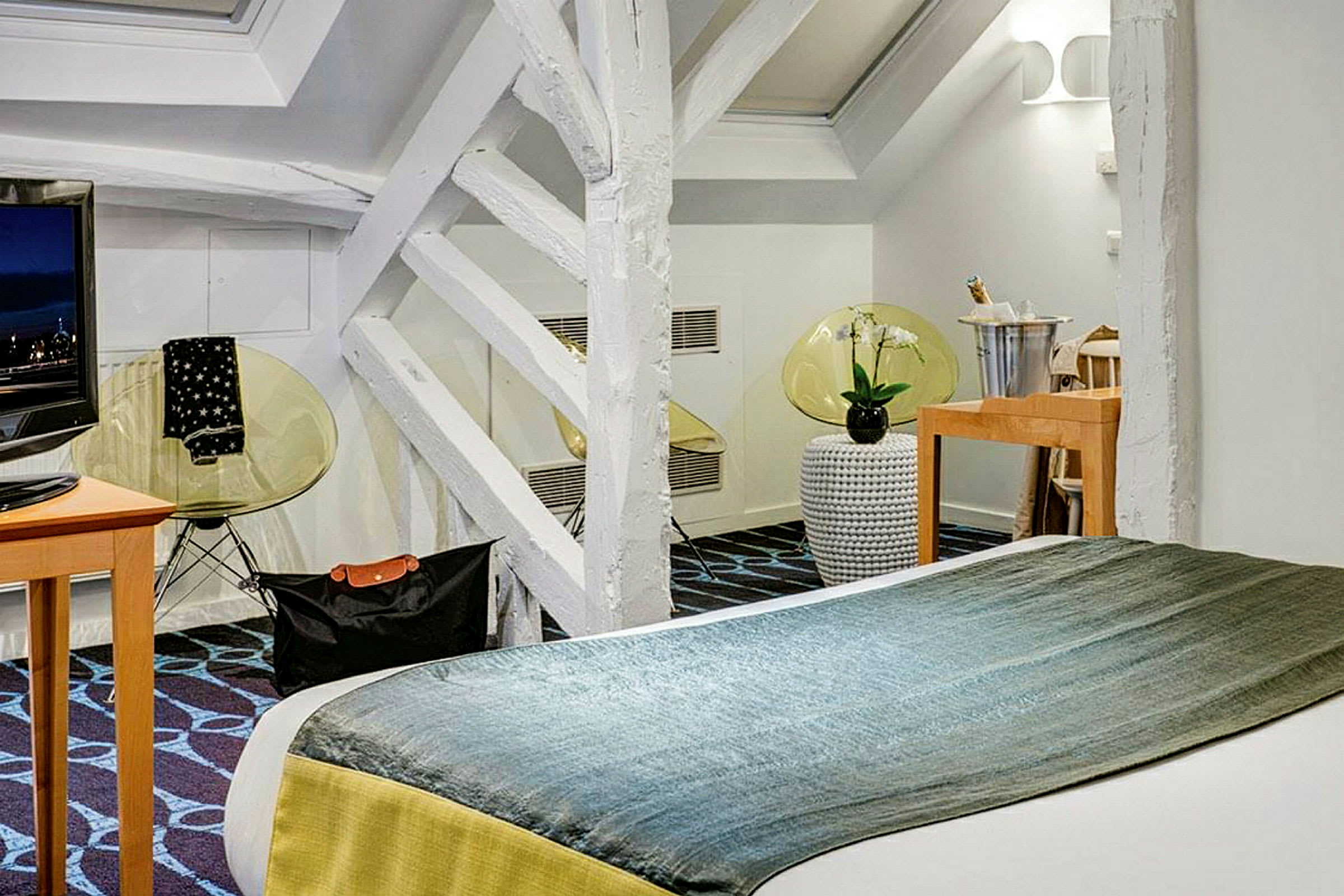 Ett modernt hotellrum med dubbelsäng, TV och dekorativa detaljer. (AI-genererad text)