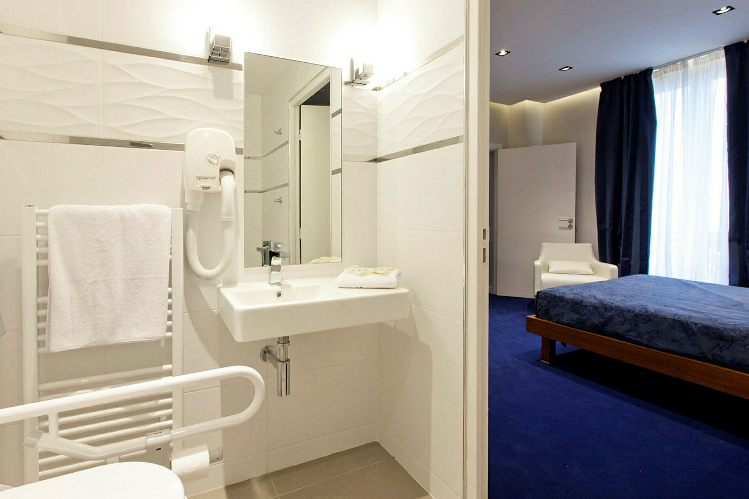 Bild av ett hotellrum med badrum i förgrunden och sovrum i bakgrunden. (AI-genererad text)