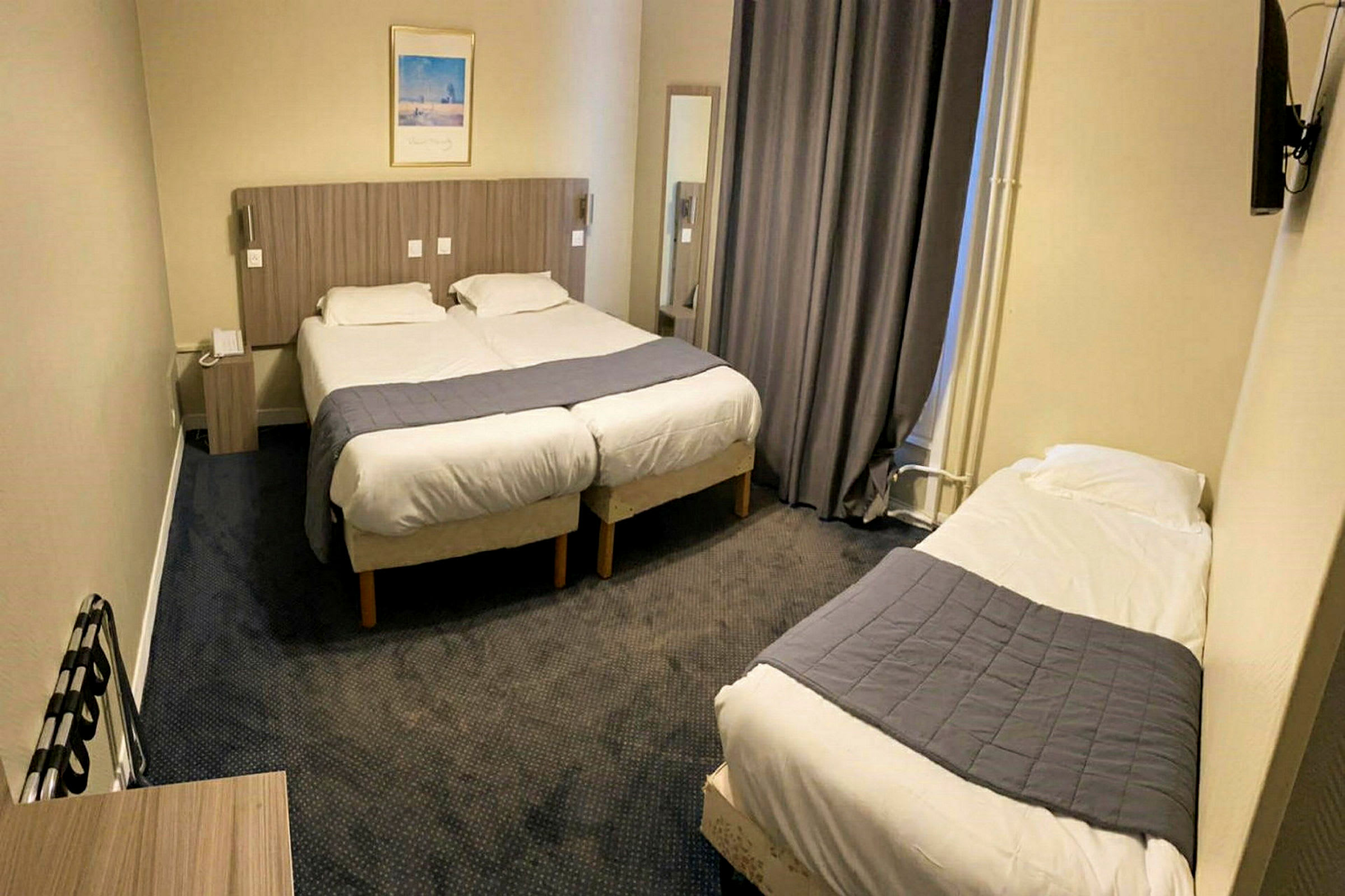 Ett hotellrum med två enkelsängar sammanställda och en separat enkelsäng. (AI-genererad text)