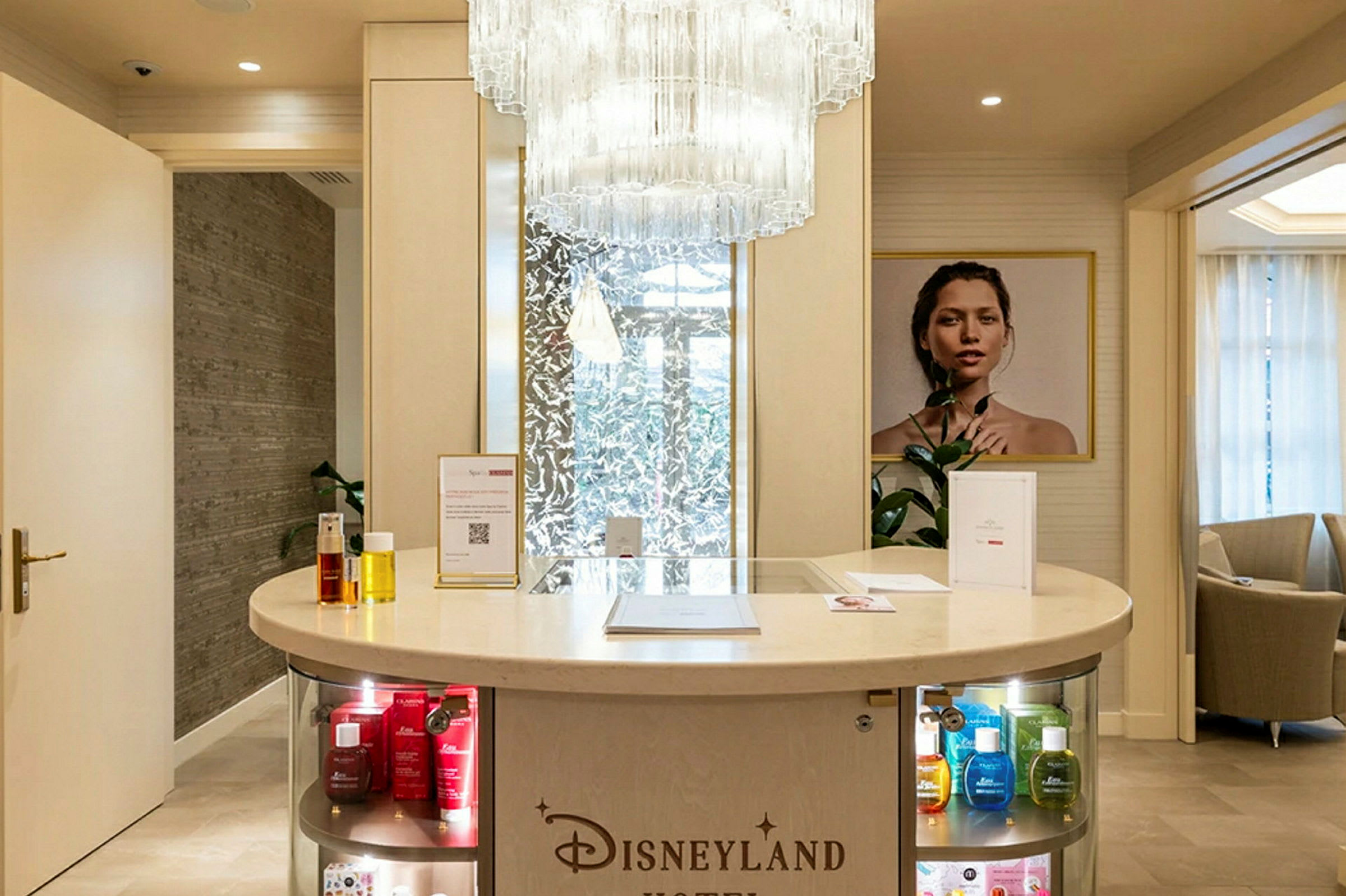 Reception med en rund disk, upplysta hyllor och en stor ljuskrona ovanför. (AI-genererad text)