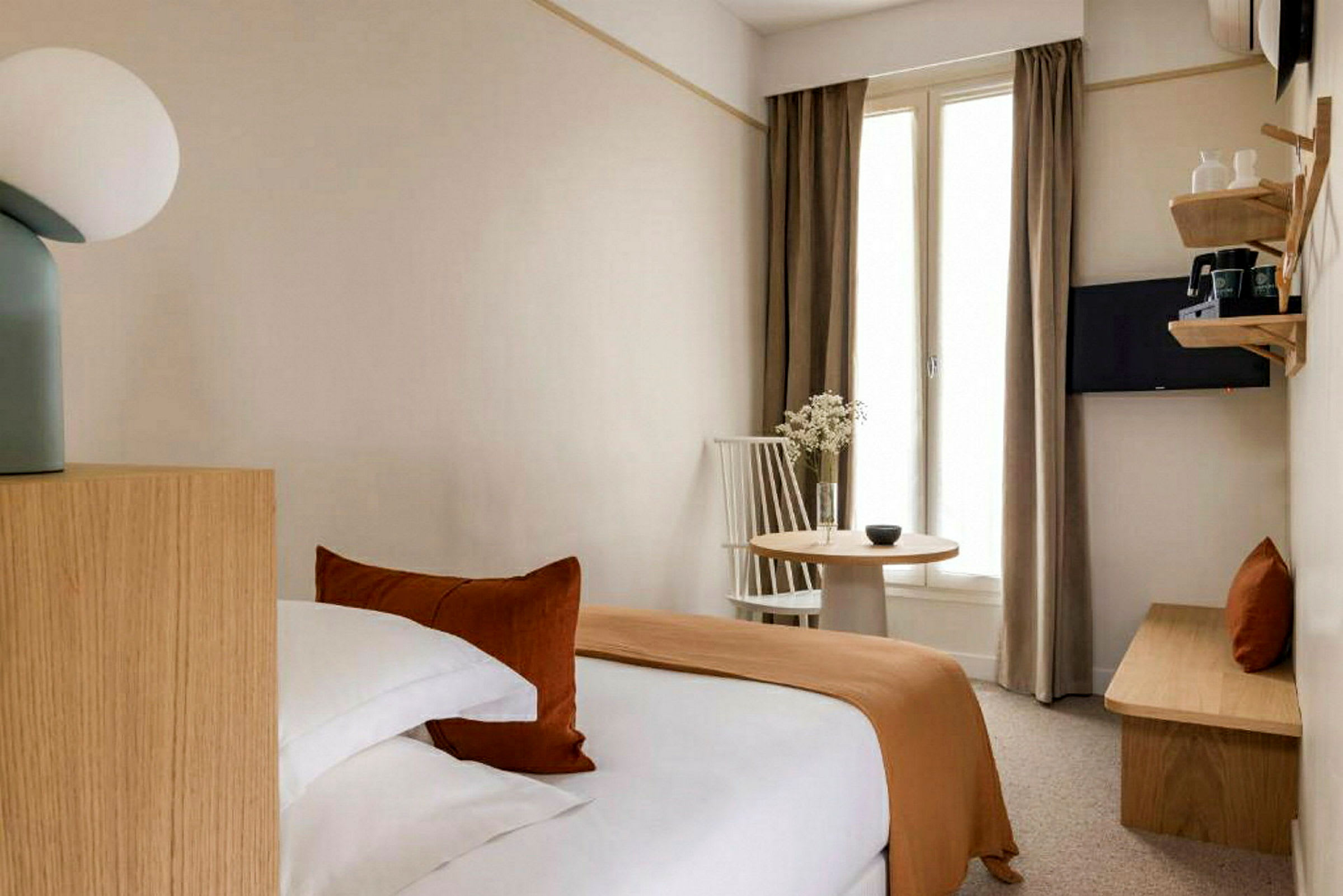 Ett hotellrum med en säng, ett bord, och en stol. (AI-genererad text)