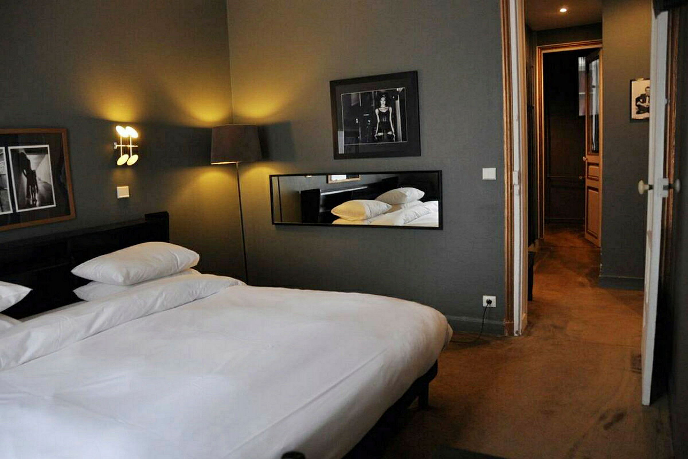 Ett hotellrum med en dubbelsäng, väggkonst och belysning. (AI-genererad text)