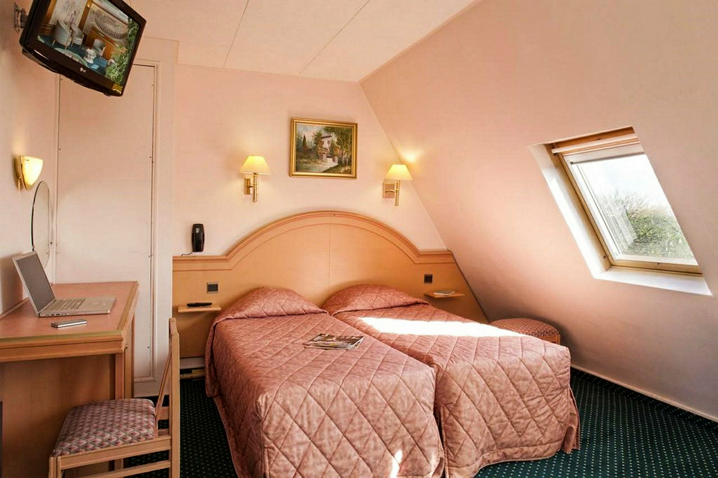 Ett hotellrum med två enkelsängar klädda i matchande sängöverkast. Ett litet skrivbord och en stol står vid sidan, och en lutande fönsterruta släpper in naturligt ljus. (AI-genererad text)