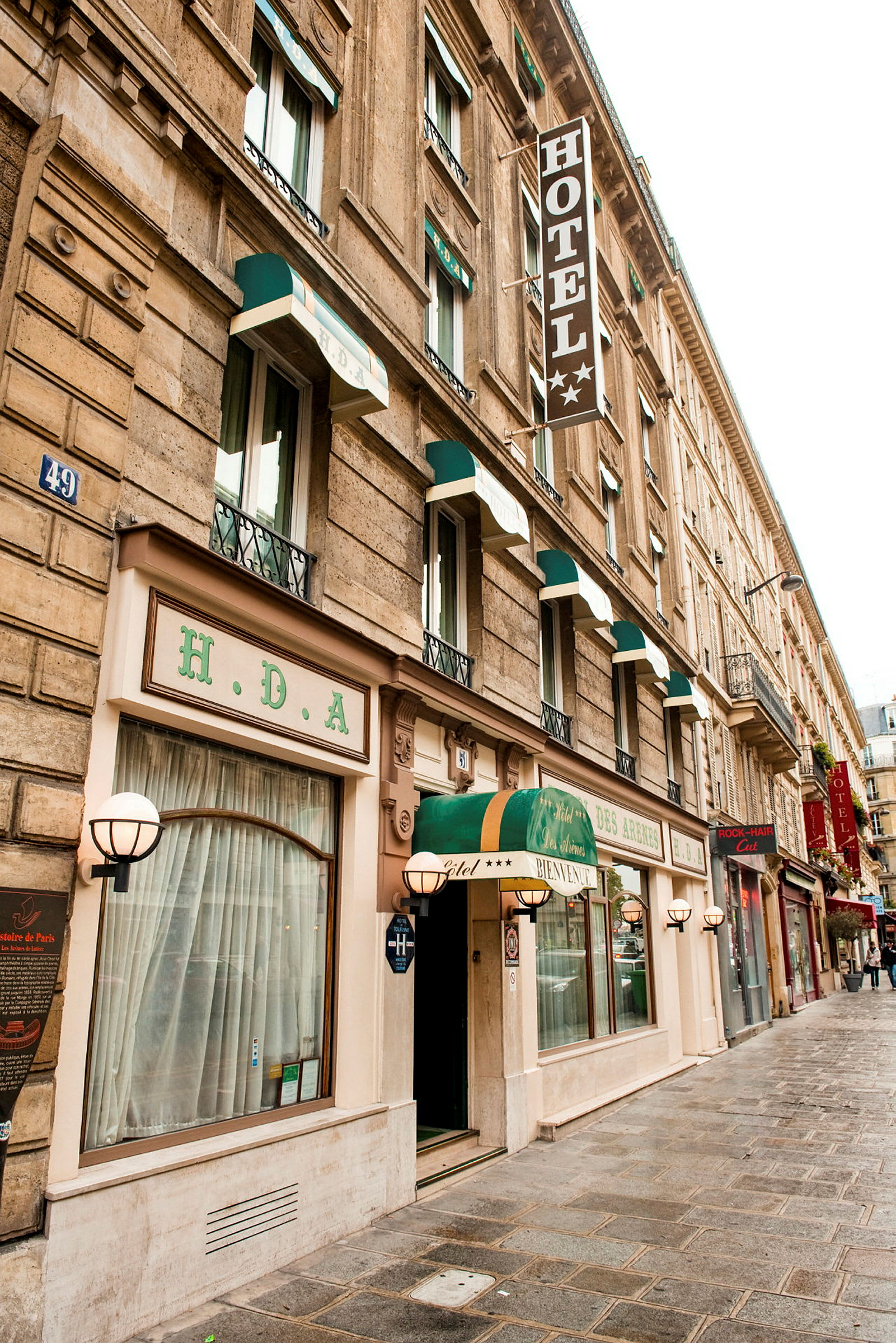Hotellfasad med flera fönster och en skylt med texten 'HOTEL'. (AI-genererad text)