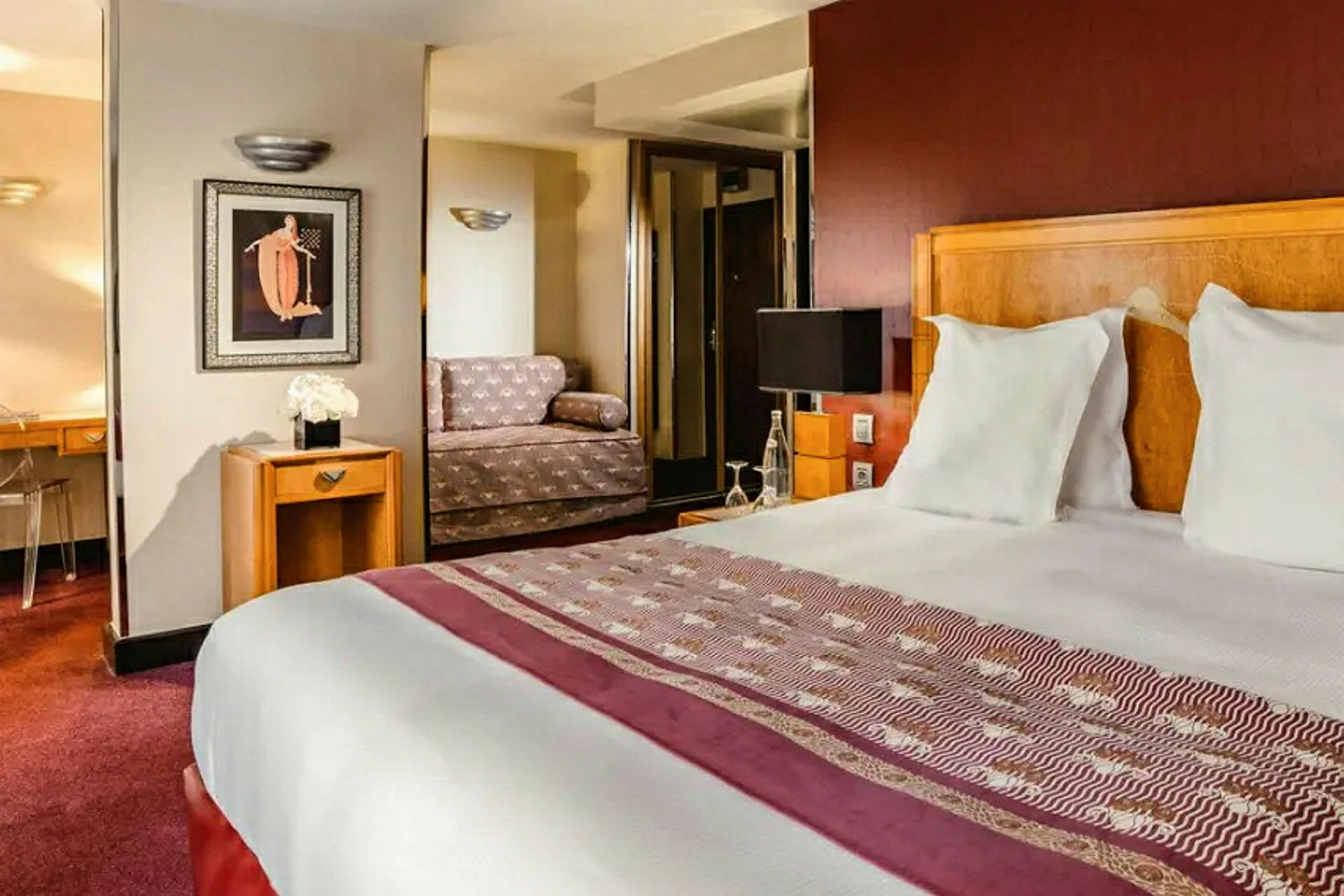 Ett hotellrum med dubbelsäng, soffa och skrivbord. (AI-genererad text)
