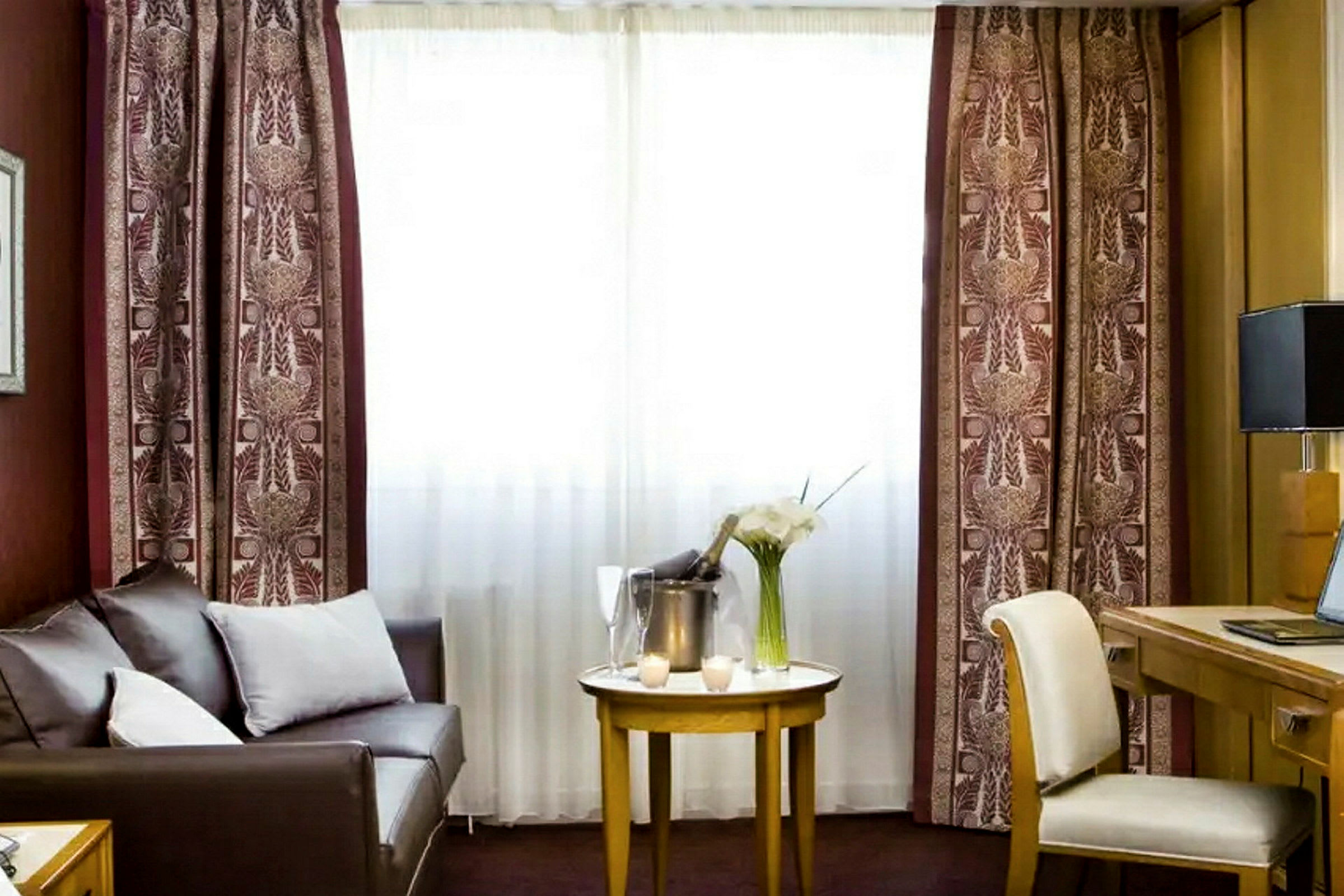 Ett hotellrum med en soffa, ett bord och en arbetsstation. (AI-genererad text)
