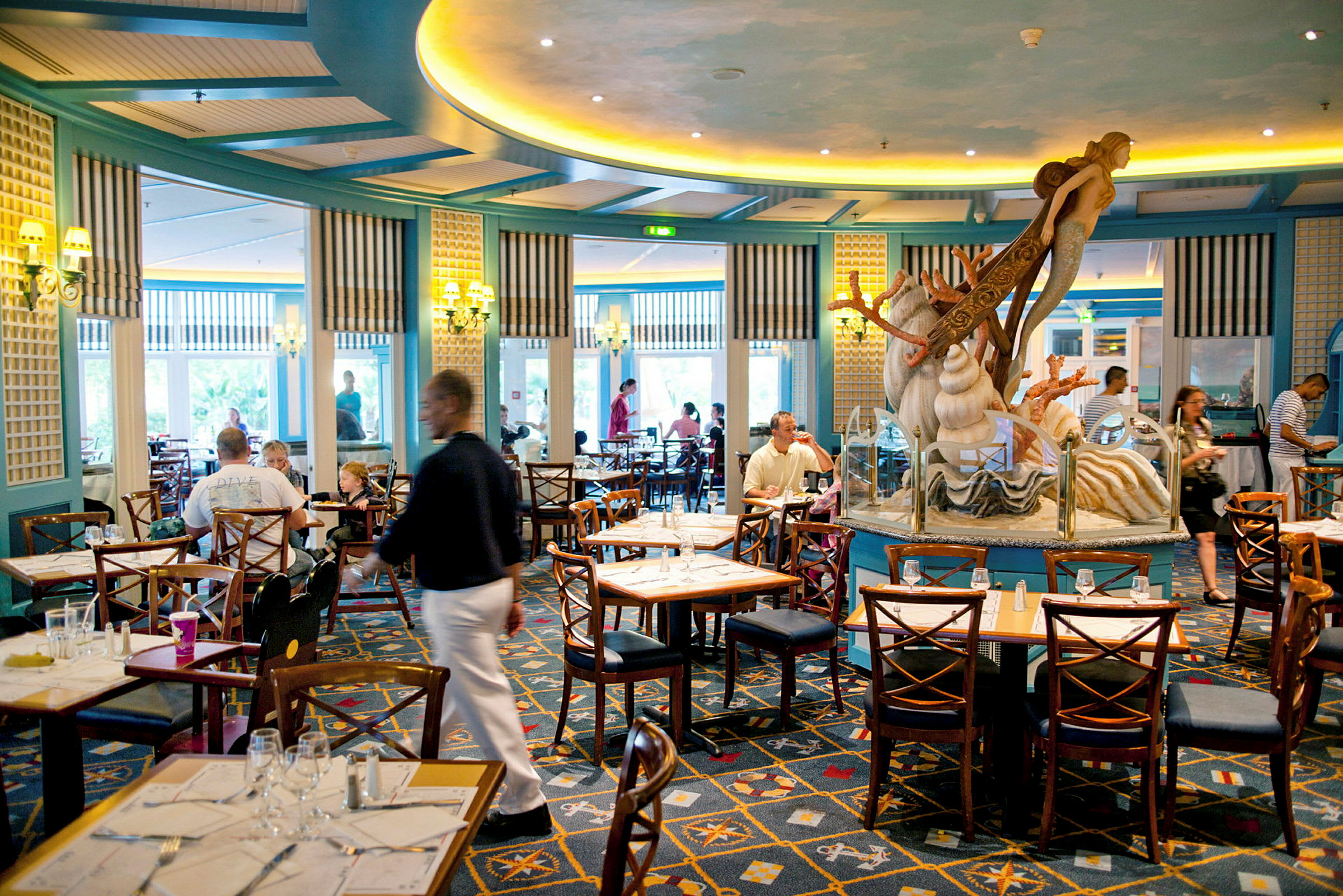 En restaurang med sittplatser och en dekoration i form av en havsfigur i mitten. (AI-genererad text)