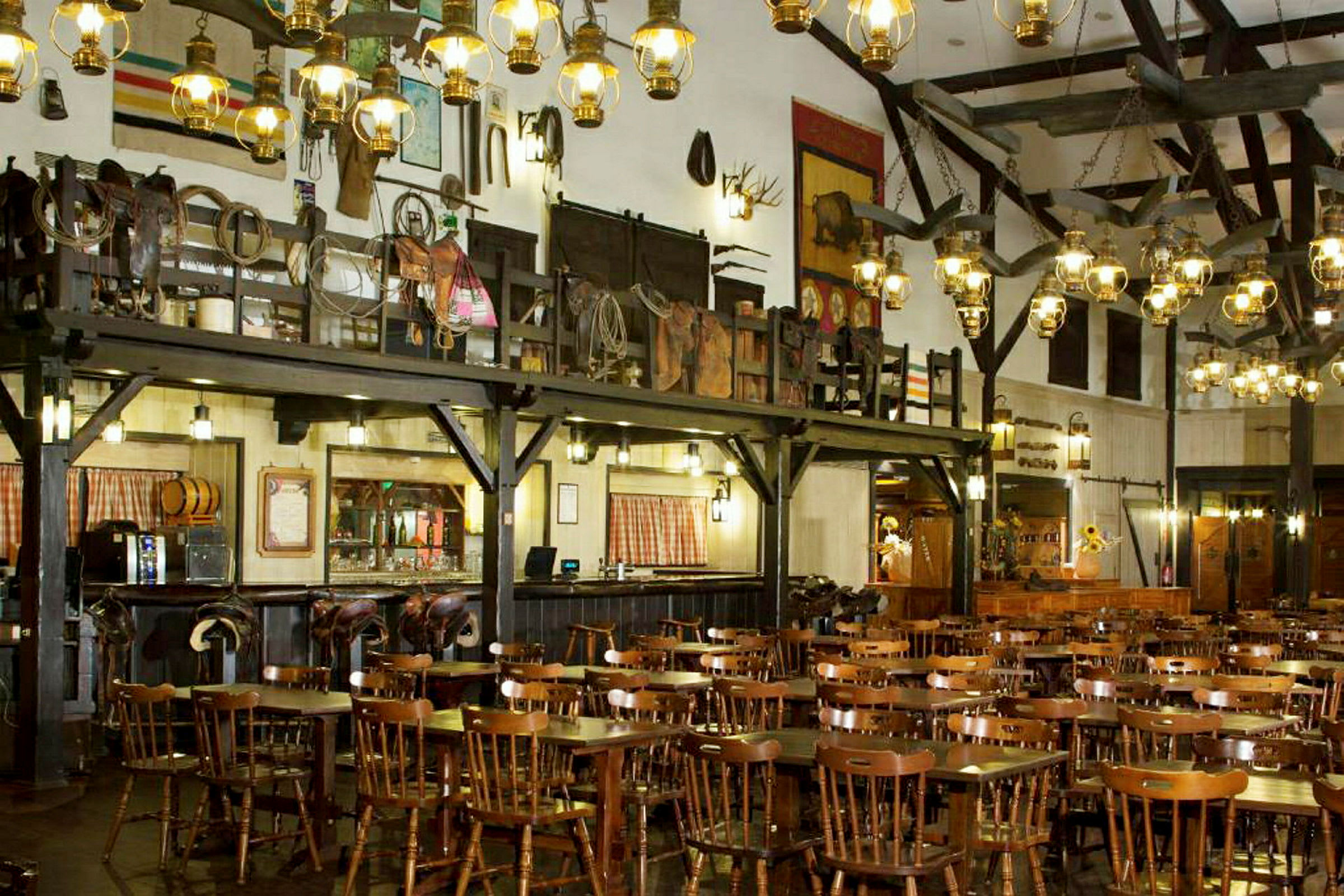 Interiör av en rustik restaurang med träbord och stolar samt dekorationer på väggarna. (AI-genererad text)