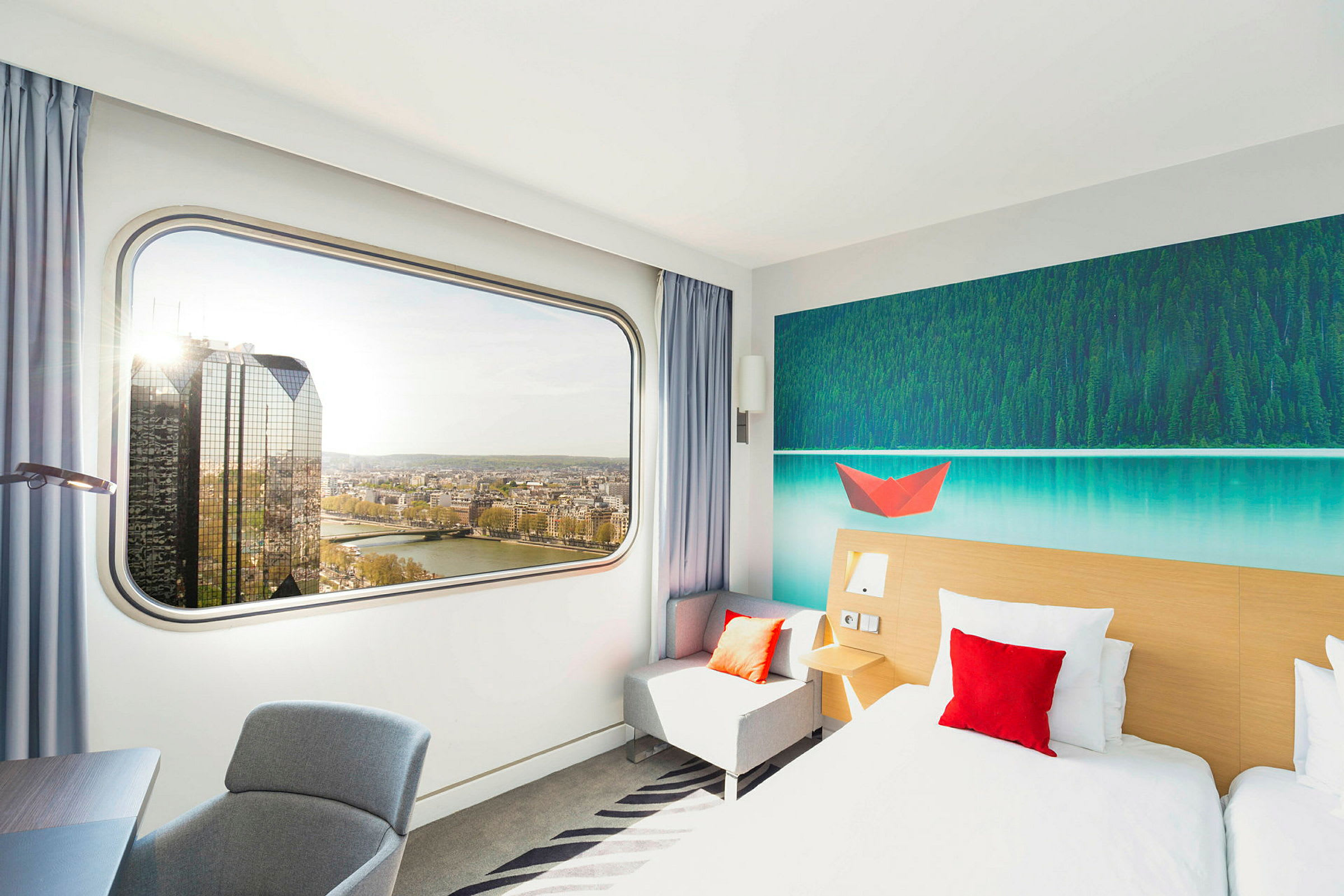 Modernt hotellrum med stort fönster och utsikt över floden. (AI-genererad text)