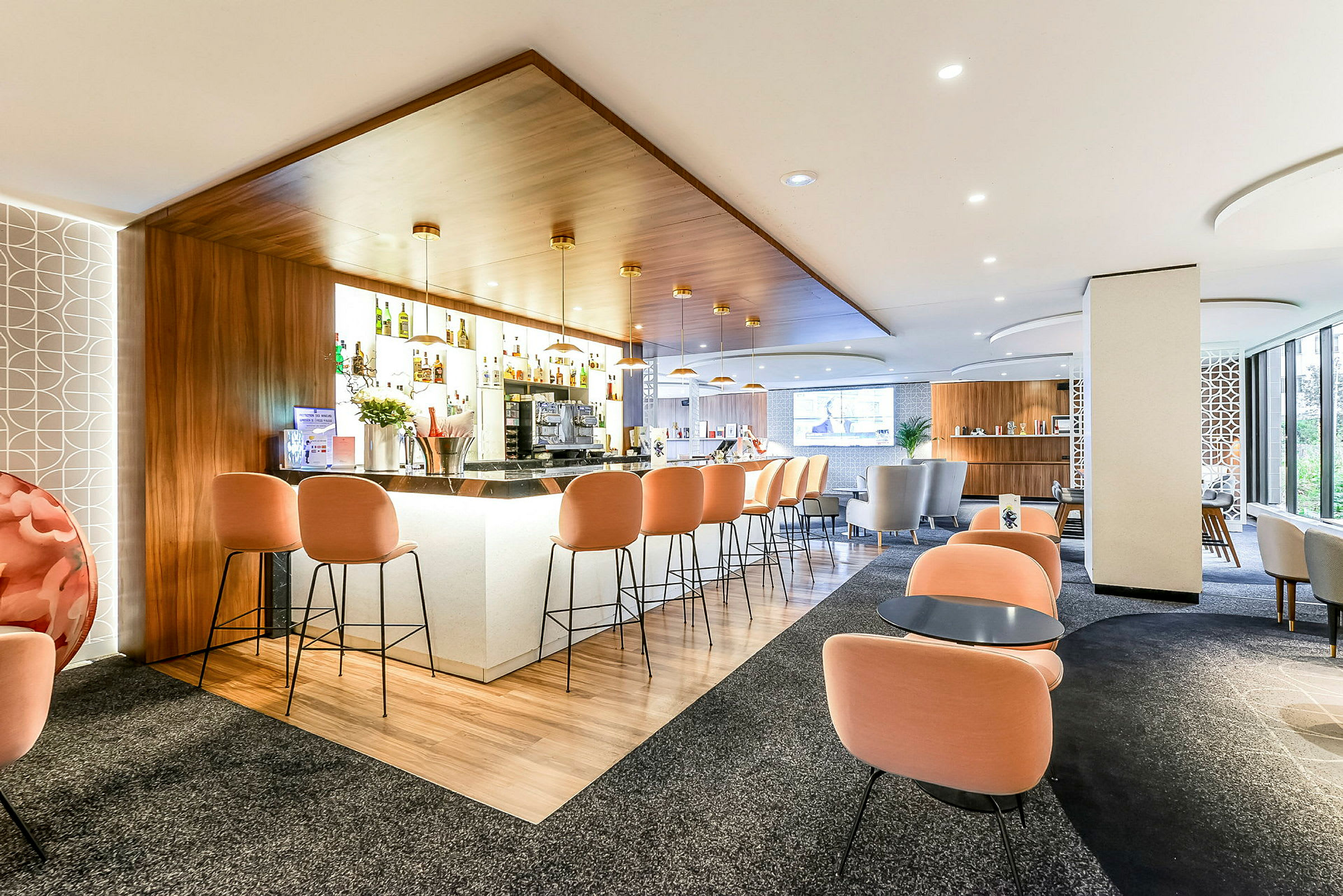 En modern hotellbar med orange stolar och en stilren design. (AI-genererad text)