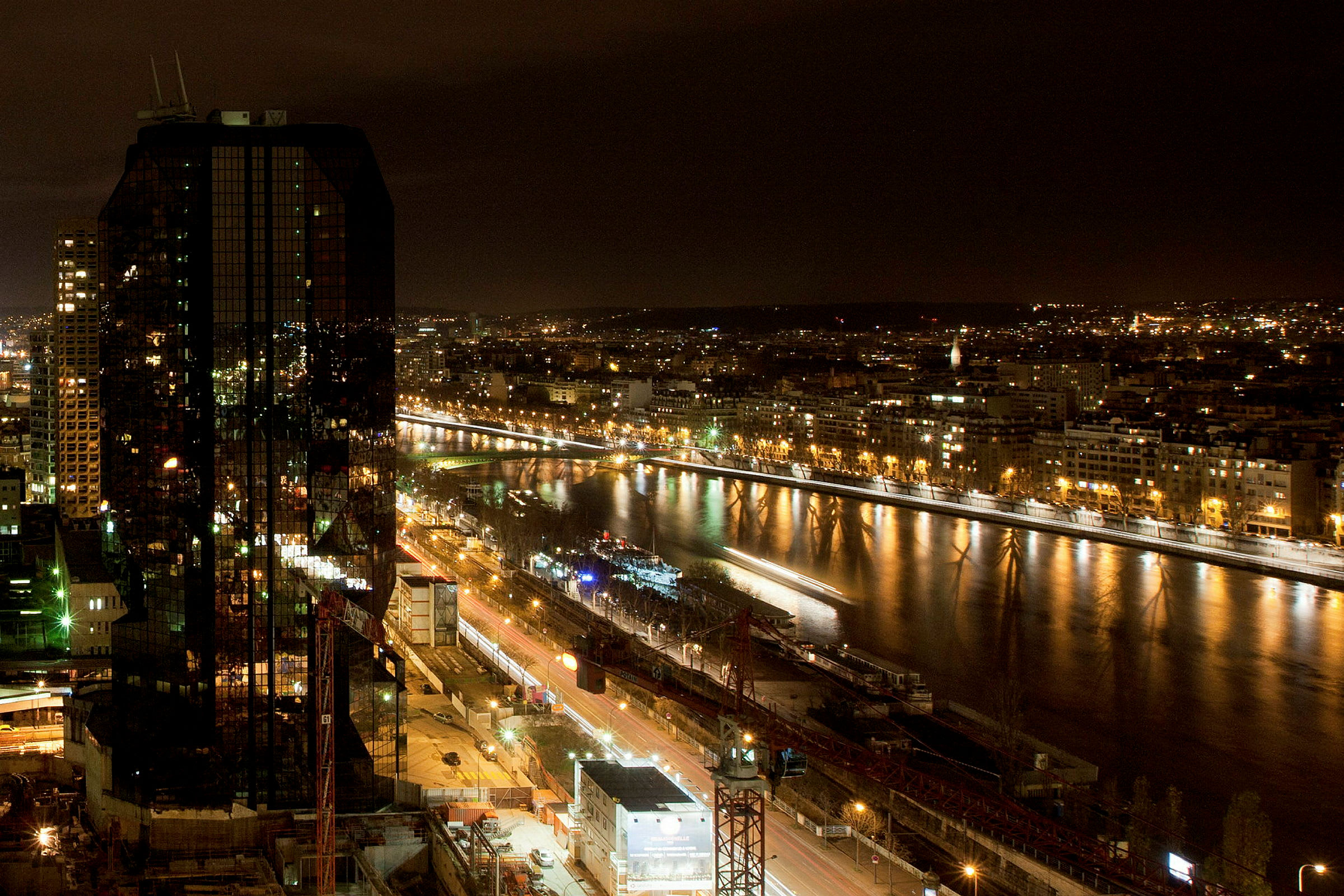 Utsikt över en stad vid natt med en flod och byggnader med ljus. (AI-genererad text)