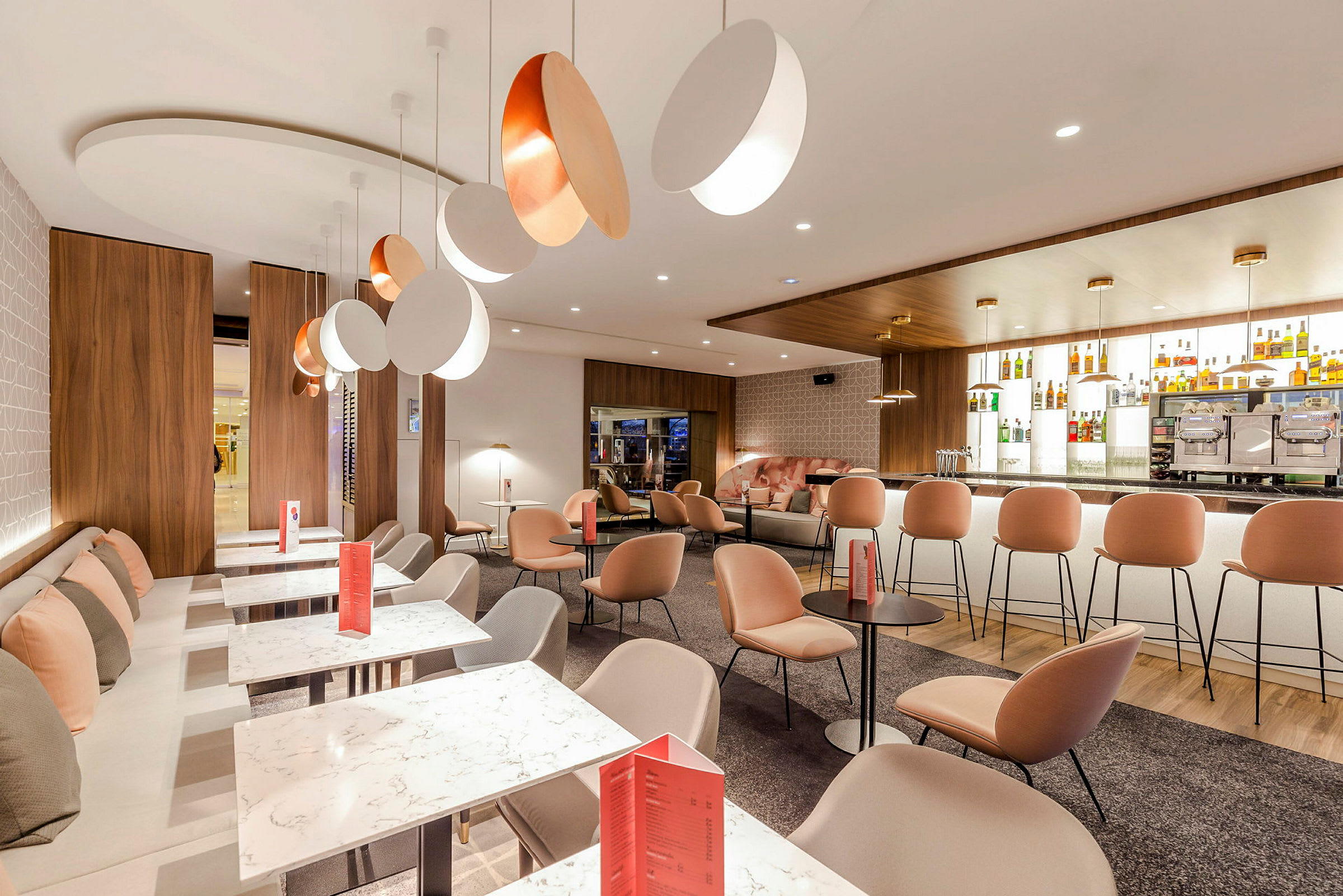 Bild av en modern lounge med bekväma sittplatser, marmorbord och en elegant bardisk. (AI-genererad text)