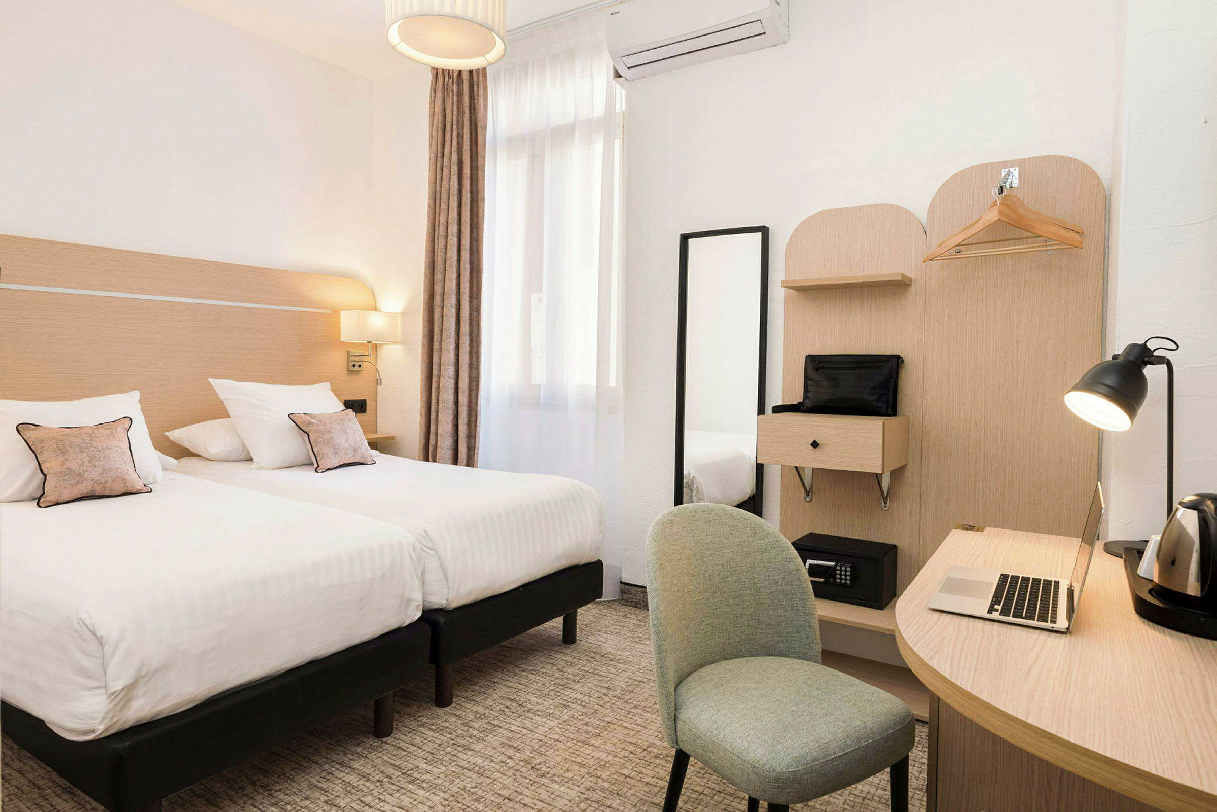 Hotelrum med två enkelsängar, ett skrivbord, stol och garderob. (AI-genererad text)