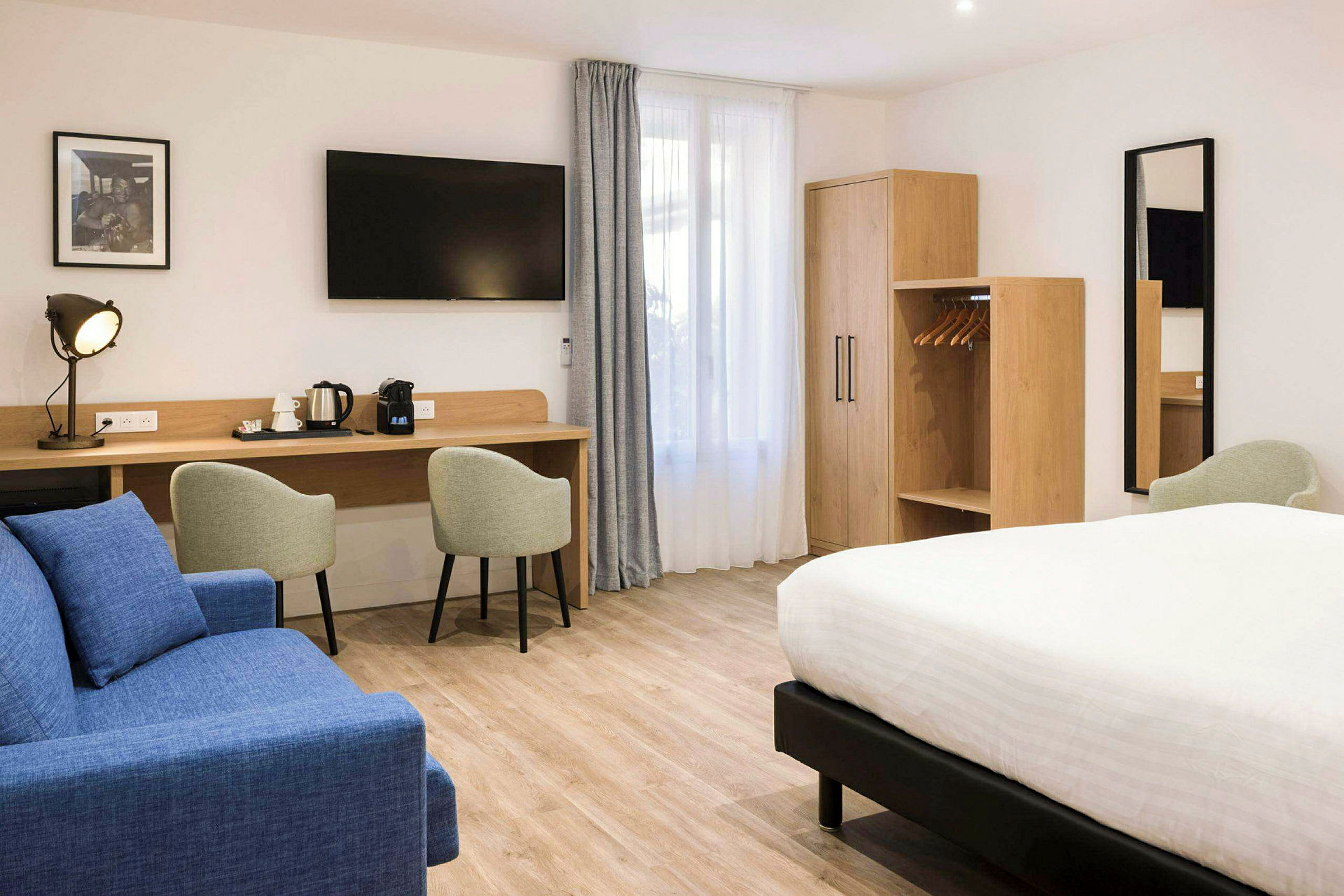 Hotellrum med dubbelsäng, sittmöbler, arbetsbord och garderob. (AI-genererad text)