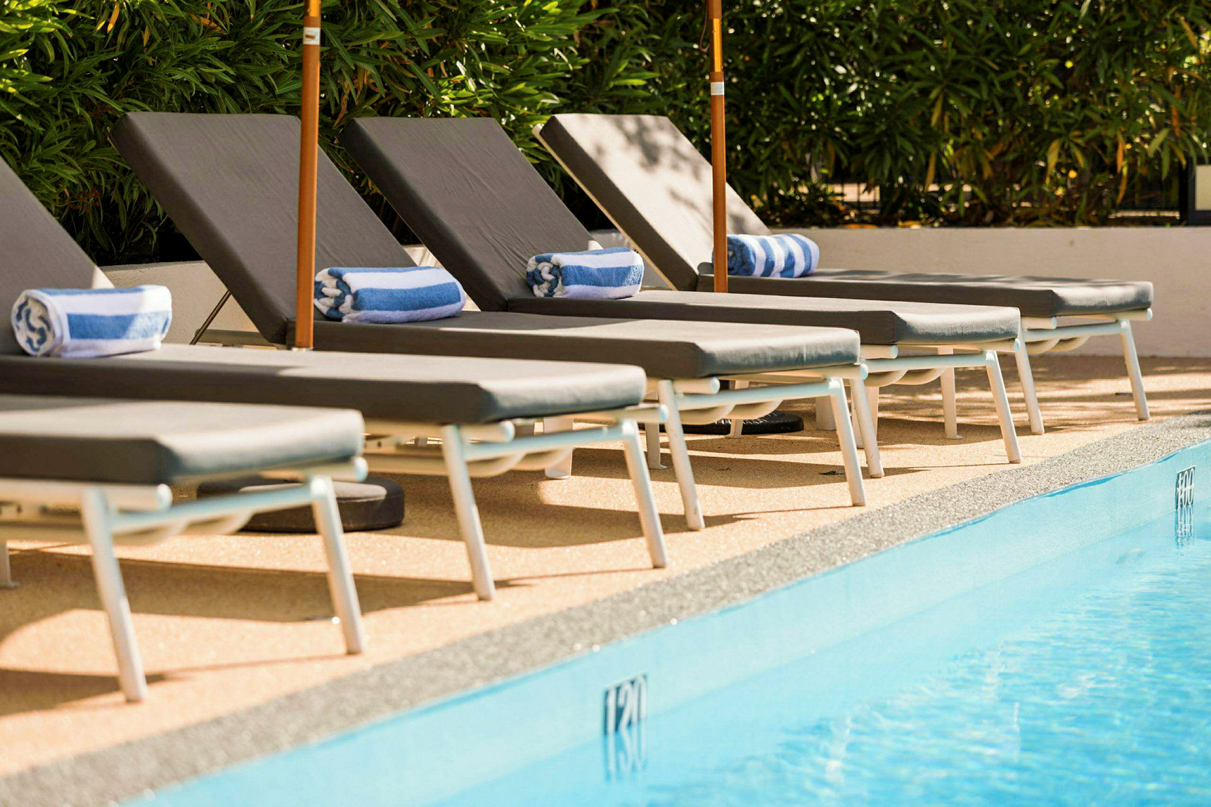 Solstolar med handdukar vid en pool. (AI-genererad text)