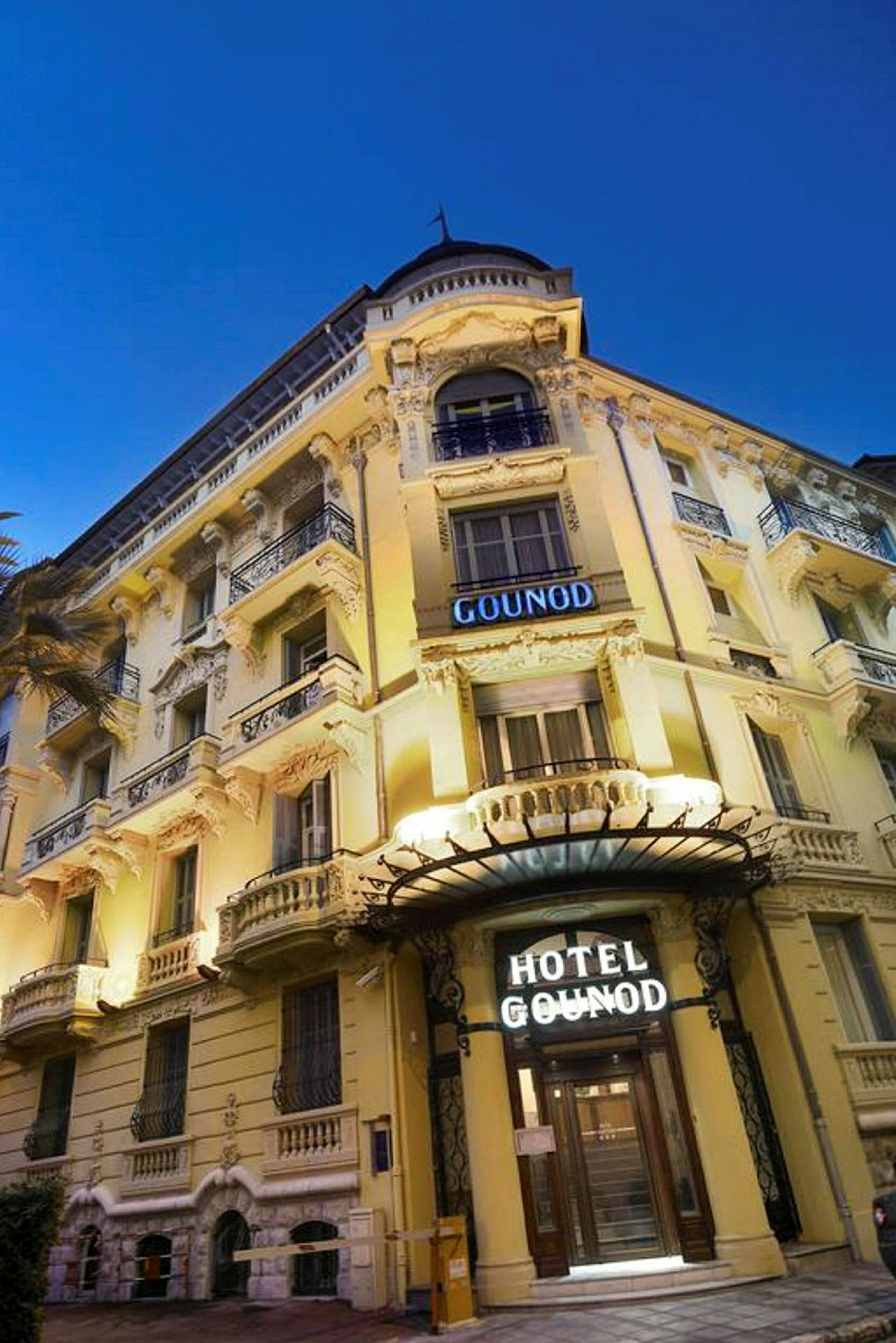 Fasad av Hotel Gounod, en byggnad med klassisk arkitektur och dekorationer. (AI-genererad text)