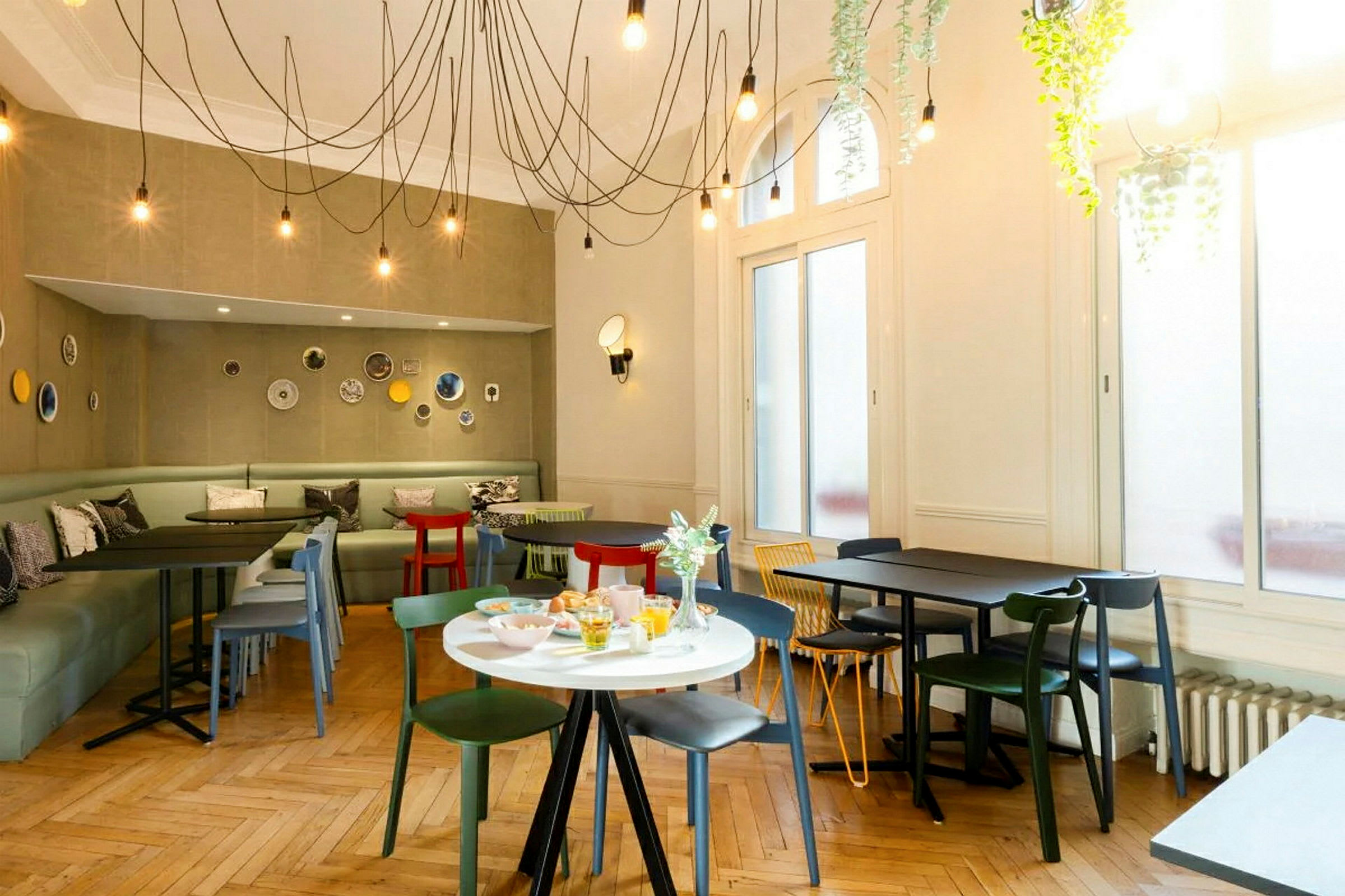 Ett modernt inrett café med färgglada stolar och bord samt dekorationer på väggarna. (AI-genererad text)