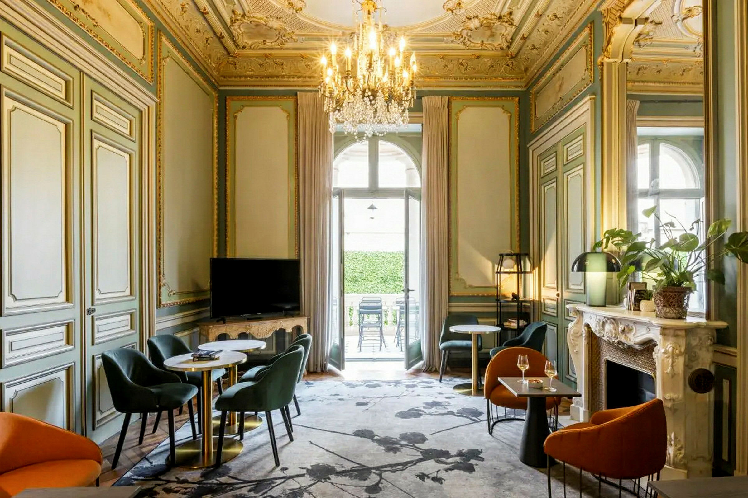 Ett elegant möblerat rum med dekorerat tak, sittgrupper och en ljuskrona. (AI-genererad text)