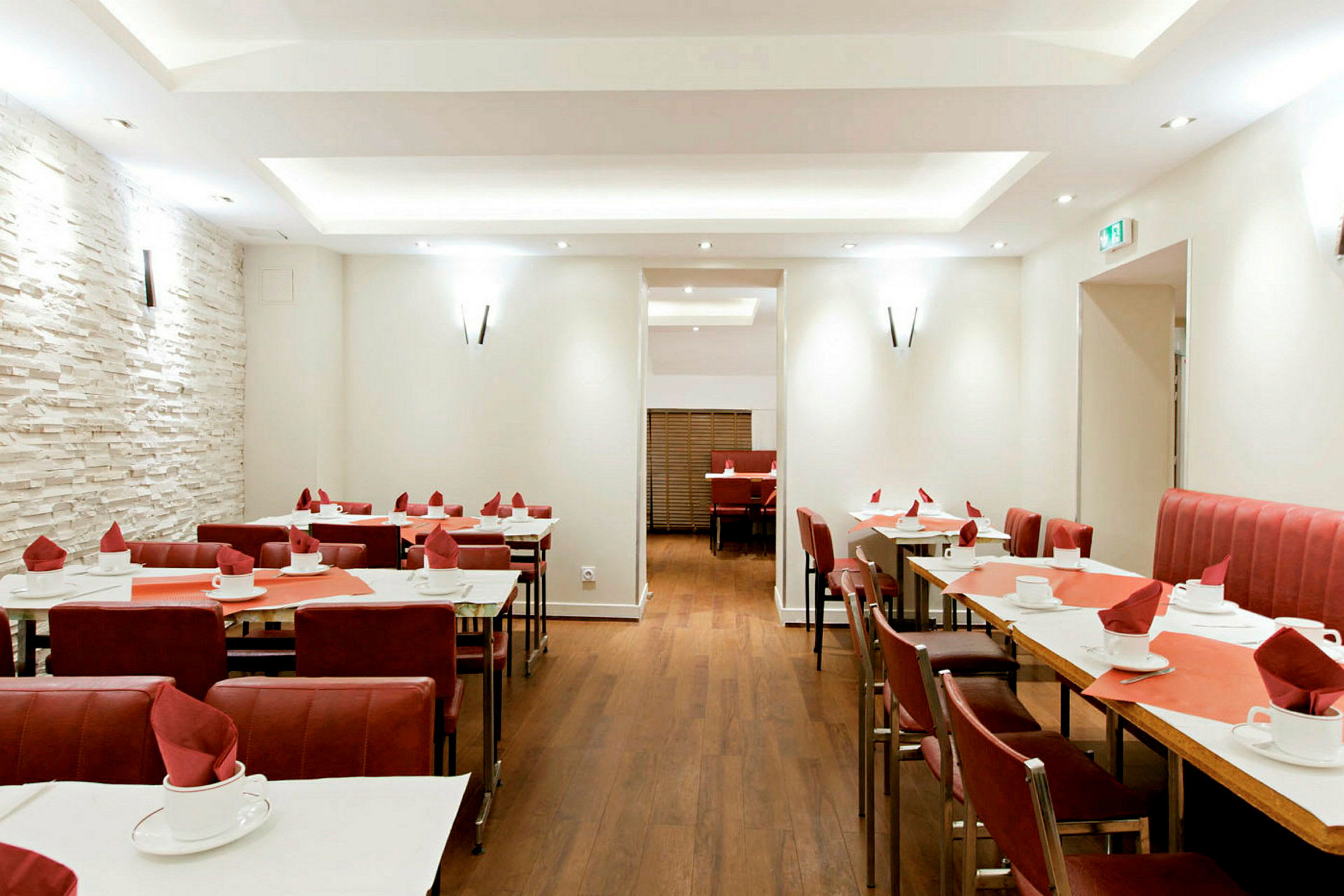 Restaurang med dukade bord och röda stolar. (AI-genererad text)