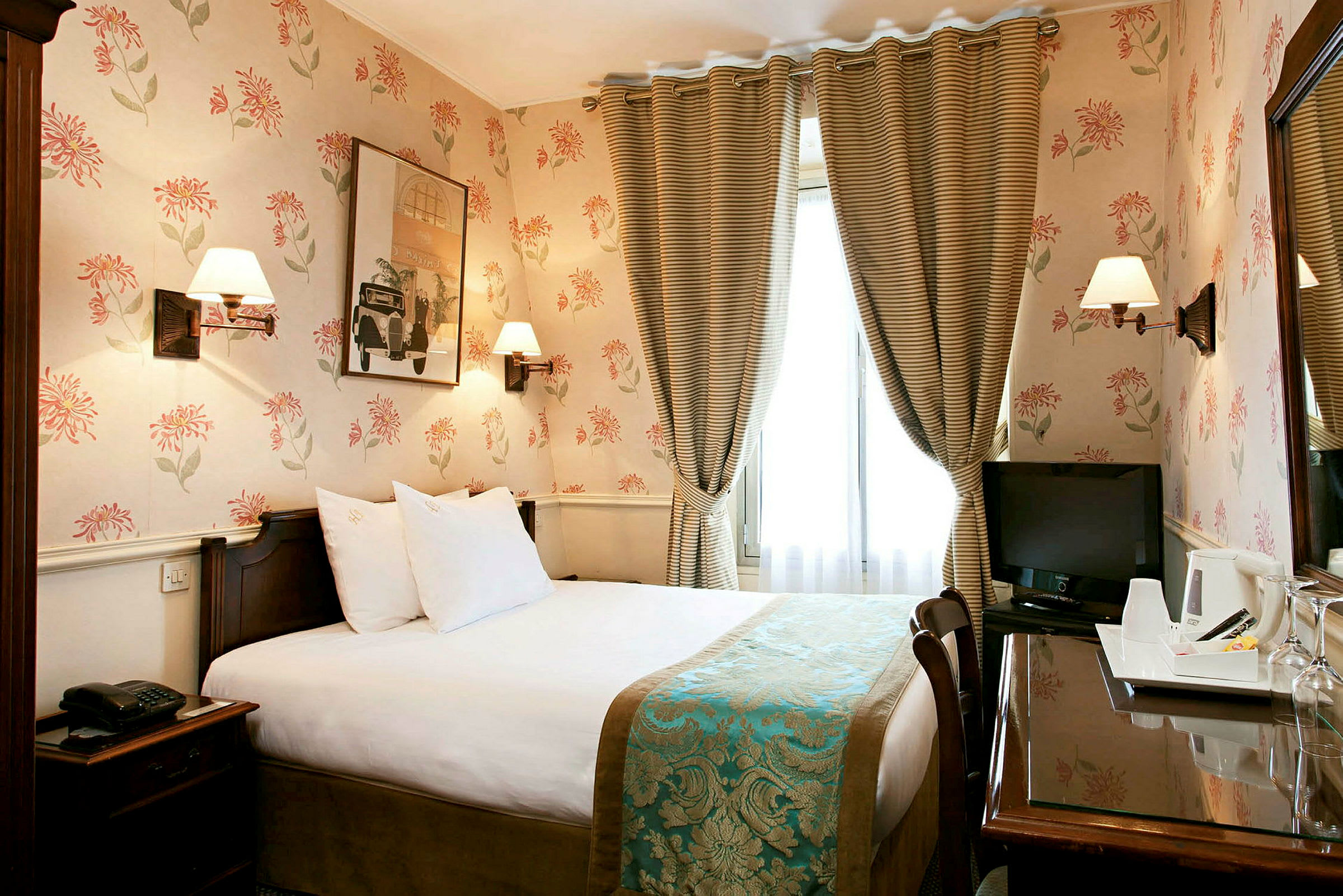 Hotellrum med blommig tapet, säng och TV. (AI-genererad text)