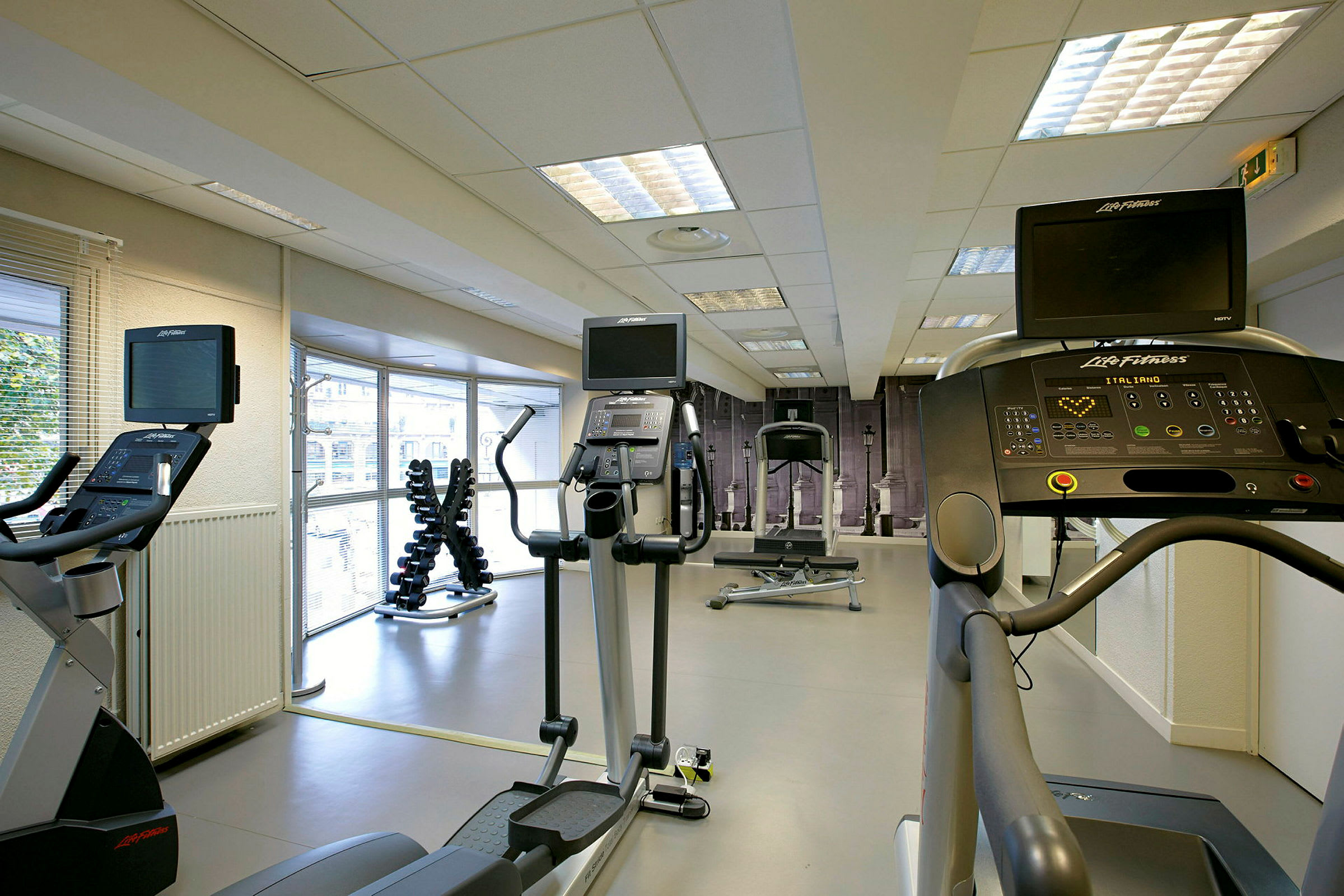 Ett gym med träningsutrustning som löpband, crosstrainers och hantlar. (AI-genererad text)