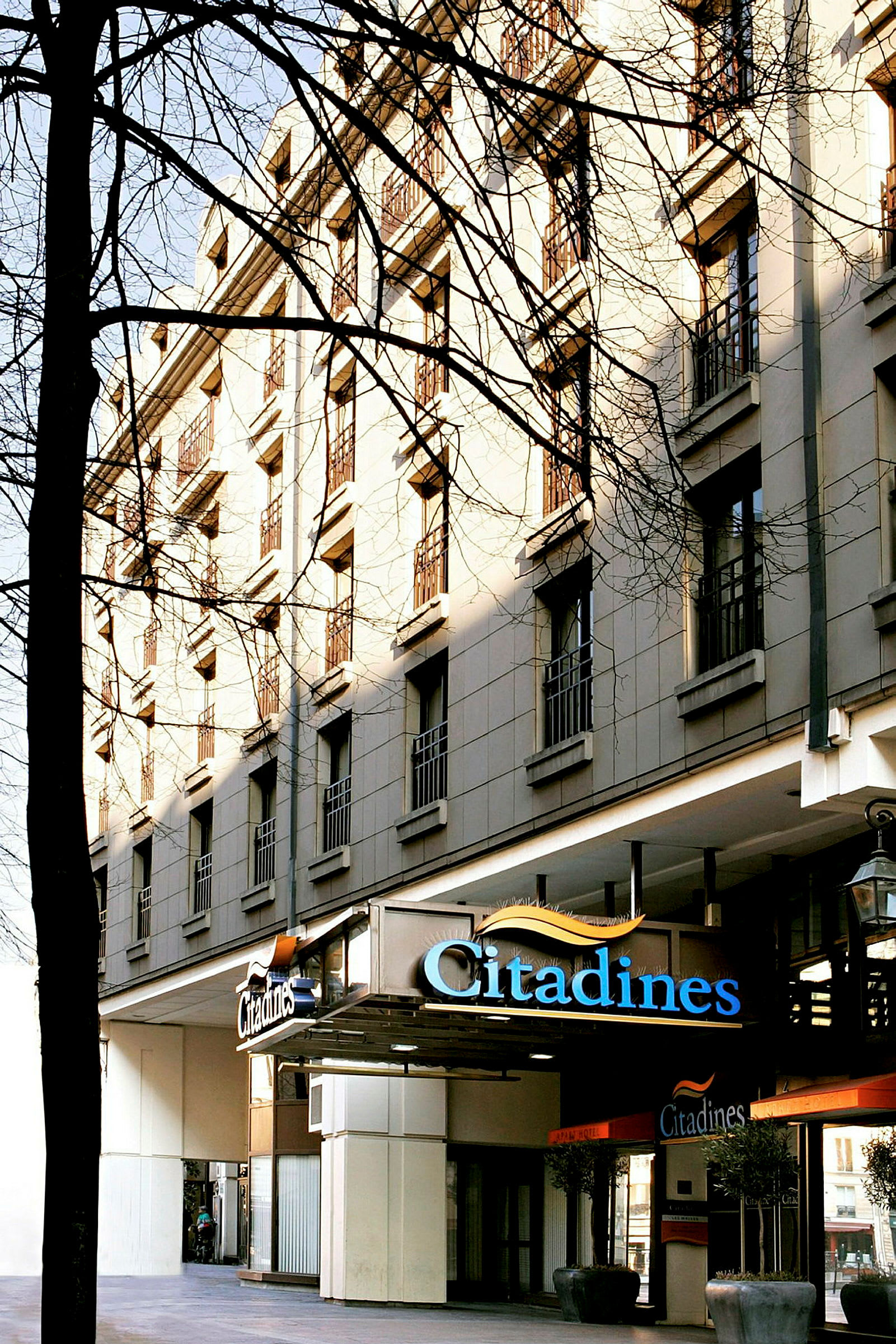 Ett flerfaldigt våningshotell med skylten 'Citadines' vid entrén. (AI-genererad text)