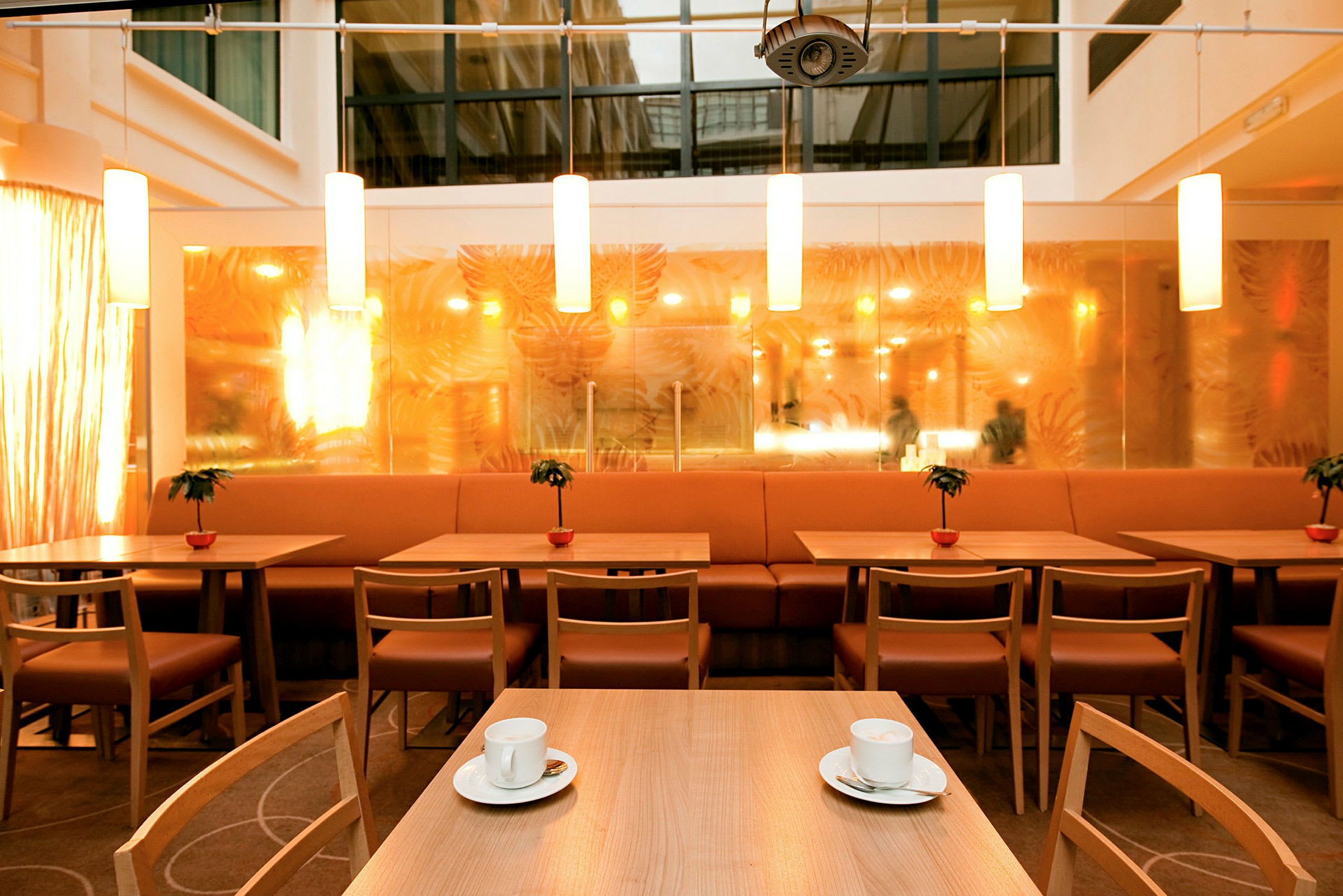 En inomhusrestaurang med bord och stolar och ljuskällor. (AI-genererad text)