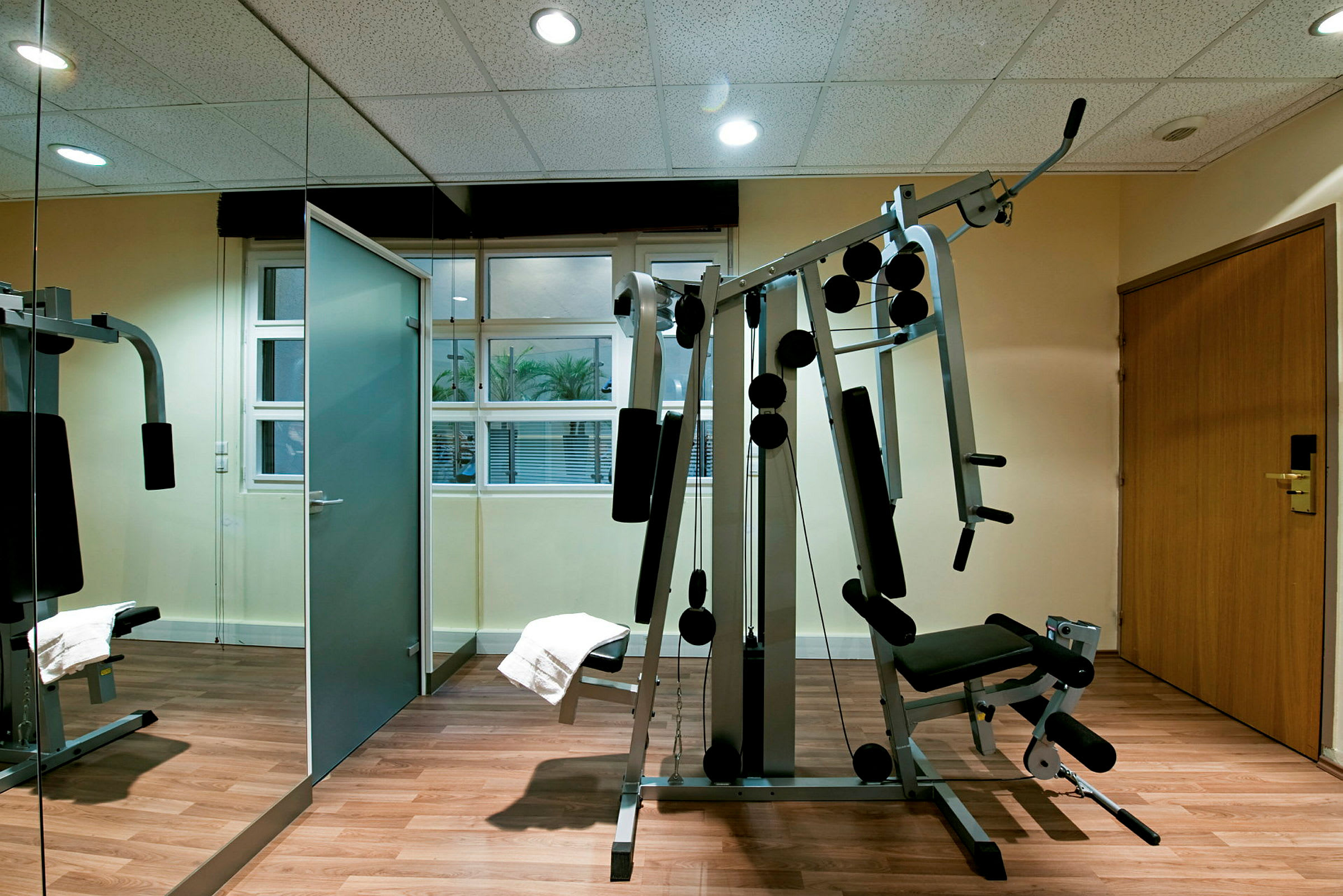 Ett gym med träningsutrustning och spegelvägg. (AI-genererad text)
