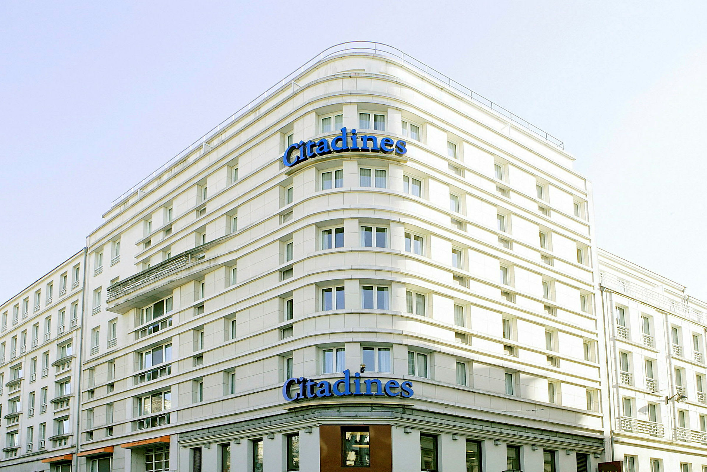 En byggnad med texten 'Citadines' på fasaden. (AI-genererad text)