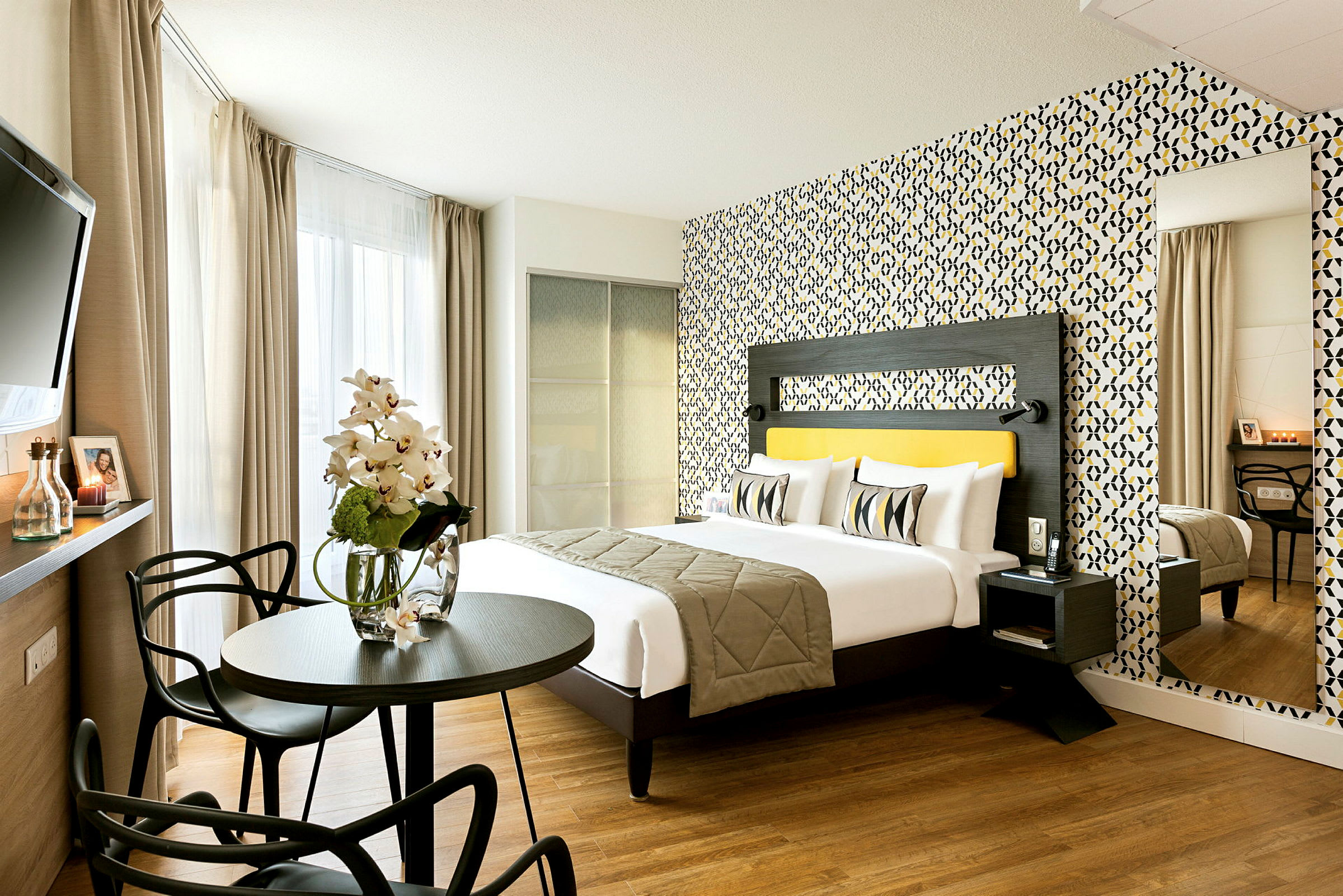 Ett modernt hotellrum med en dubbelsäng, färgglad tapet, och sittgrupp. (AI-genererad text)