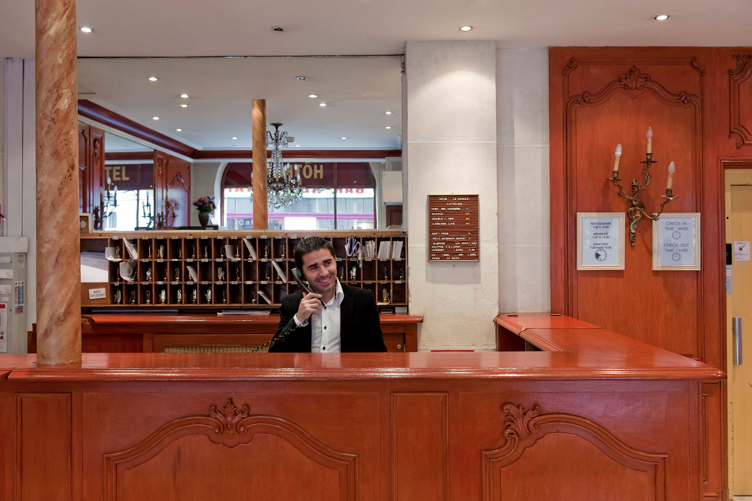 Hotellreception med träinredning, hyllor och spegel i bakgrunden. (AI-genererad text)