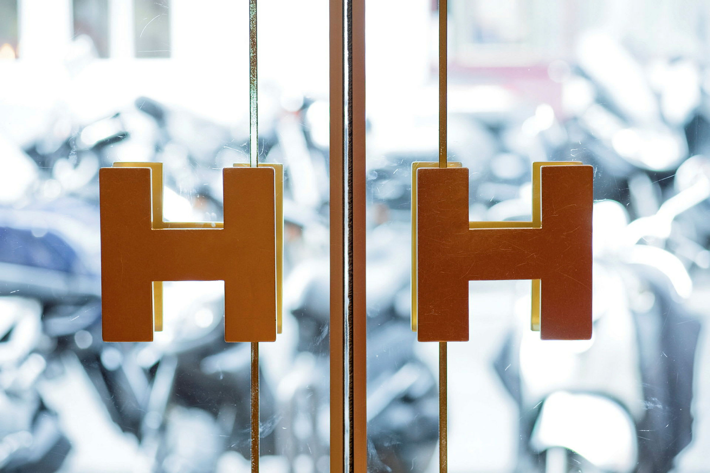 Transparenta glasdörrar med H-formade handtag. (AI-genererad text)