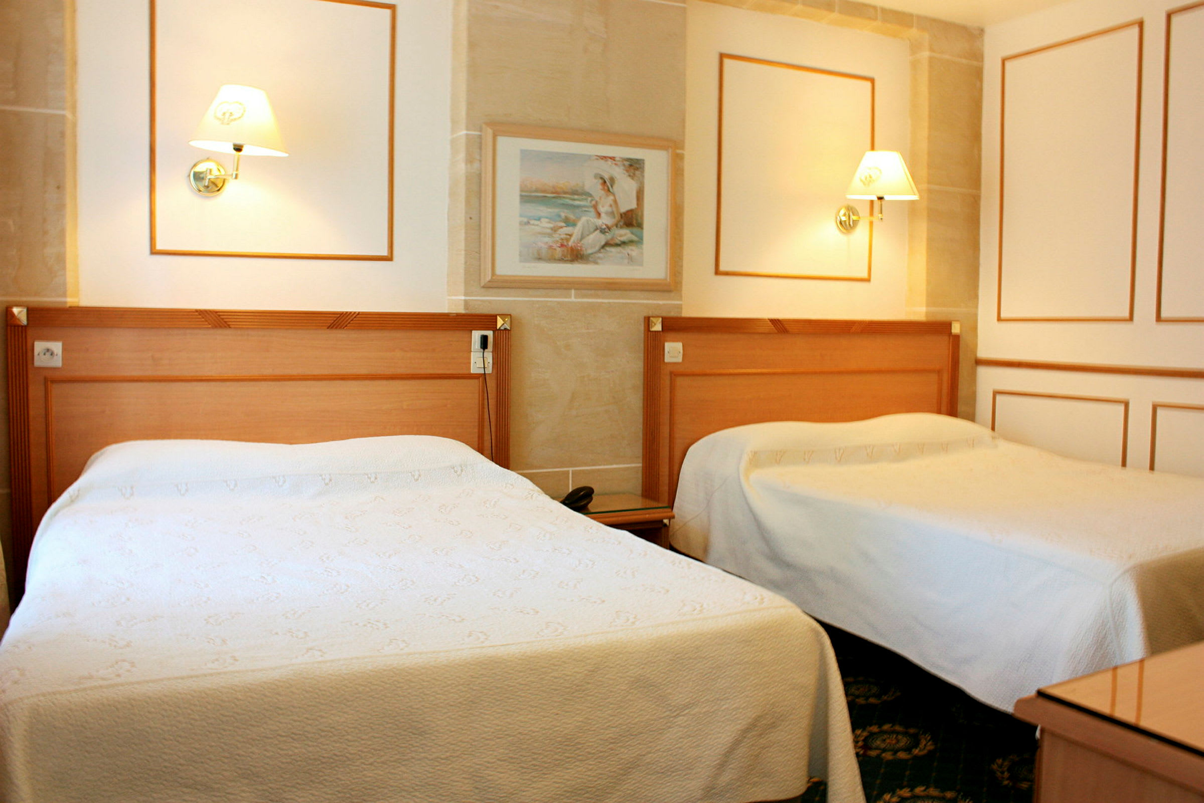 Ett hotellrum med två enkelsängar, två sänglampor och en tavla på väggen. (AI-genererad text)