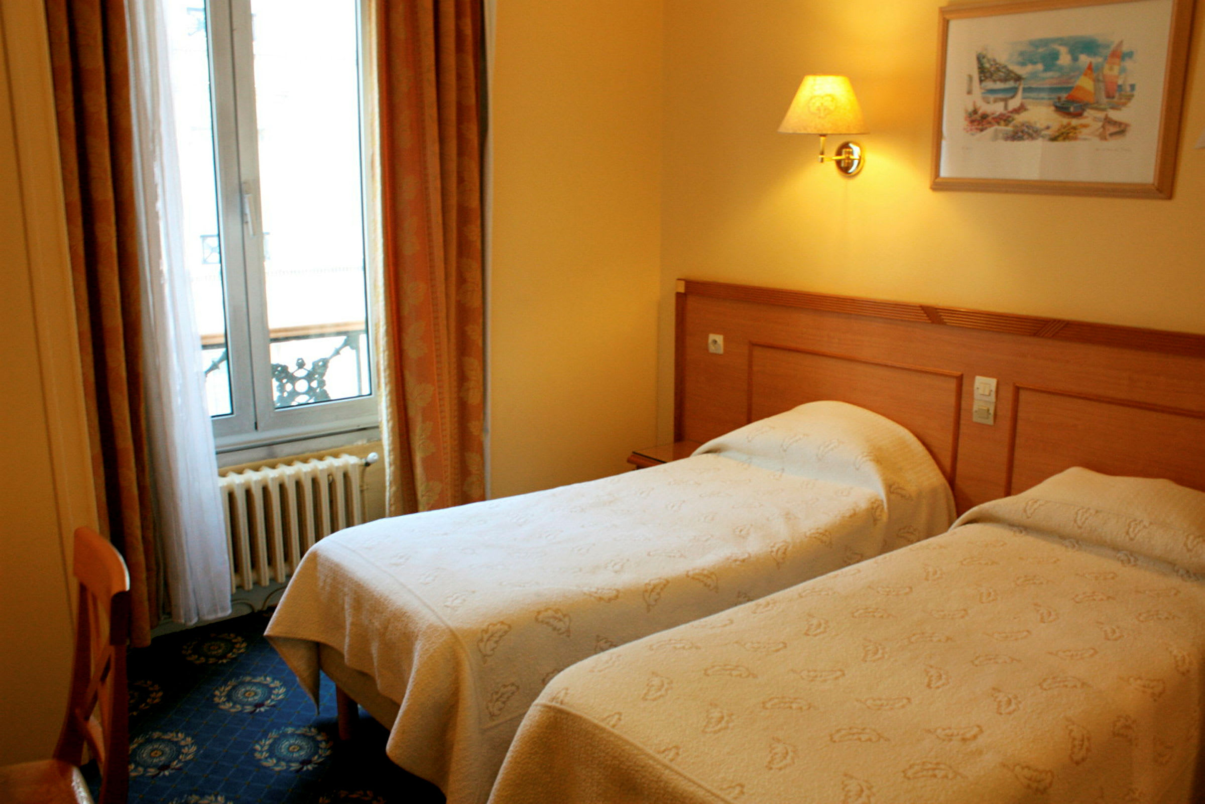 Ett hotellrum med två enkelsängar, en tavla på väggen och ett fönster med gardiner. (AI-genererad text)