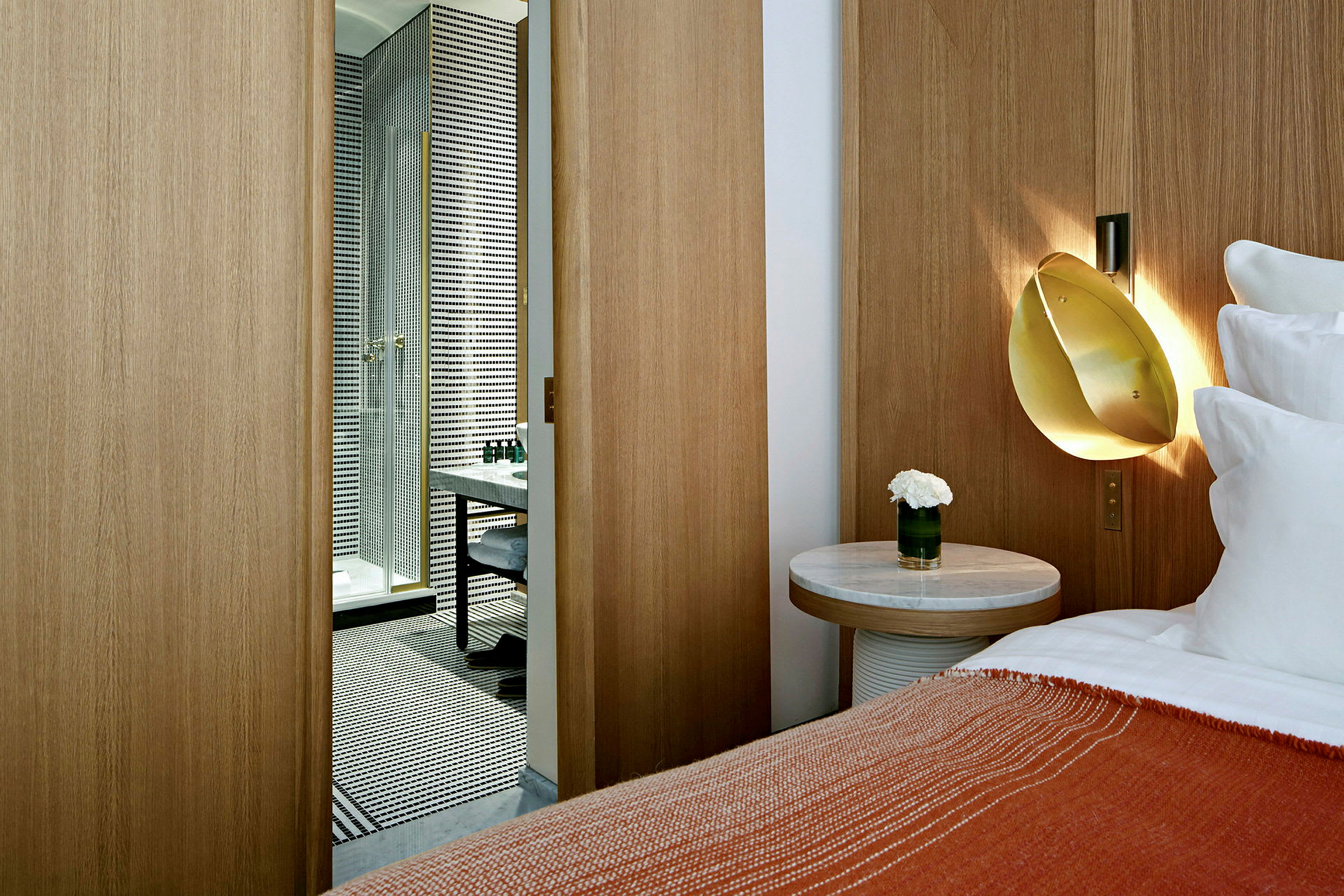 Hotellrum med modern inredning, en dörr öppnar sig till ett stilrent badrum. (AI-genererad text)