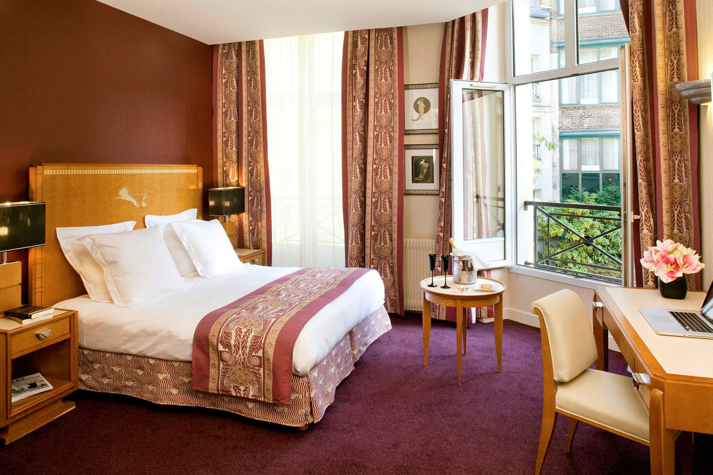 Ett hotellrum med en stor säng, eleganta möbler och en öppen balkongdörr med utsikt. (AI-genererad text)