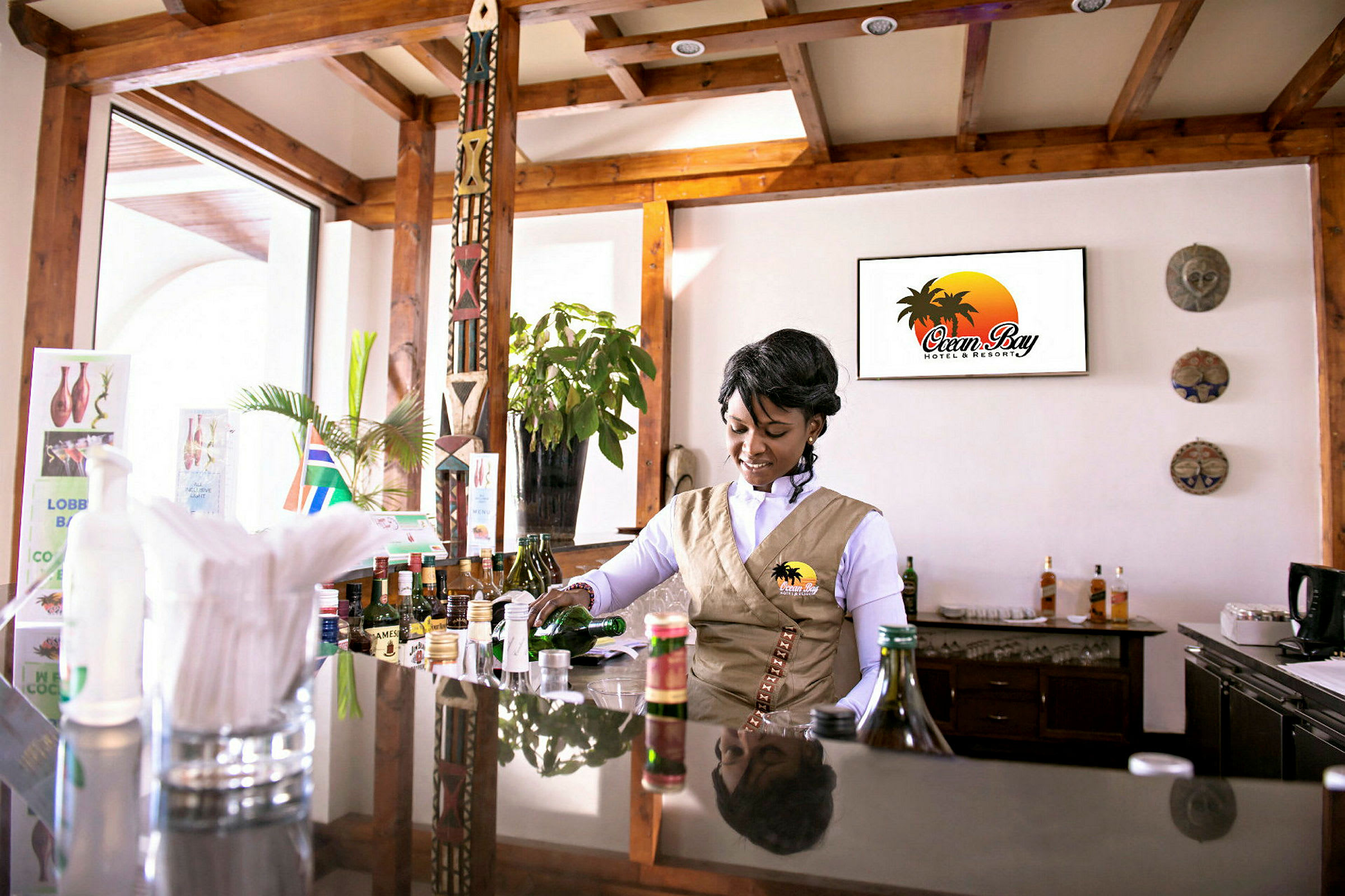 En bartender i uniform förbereder en drink vid en hotellbar. (AI-genererad text)