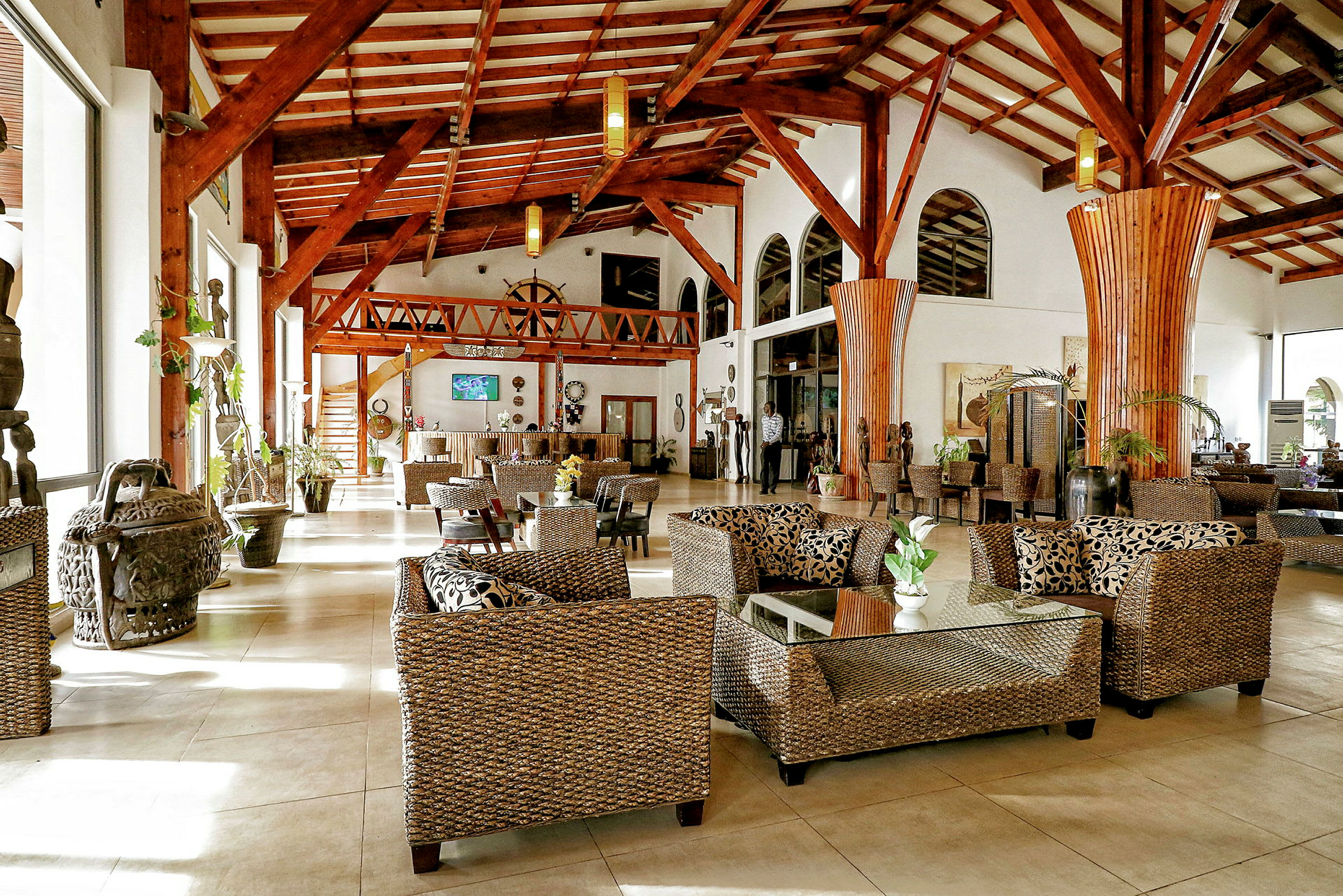 Ett elegant hotellobby med sittplatser av rotting och högt i tak. (AI-genererad text)