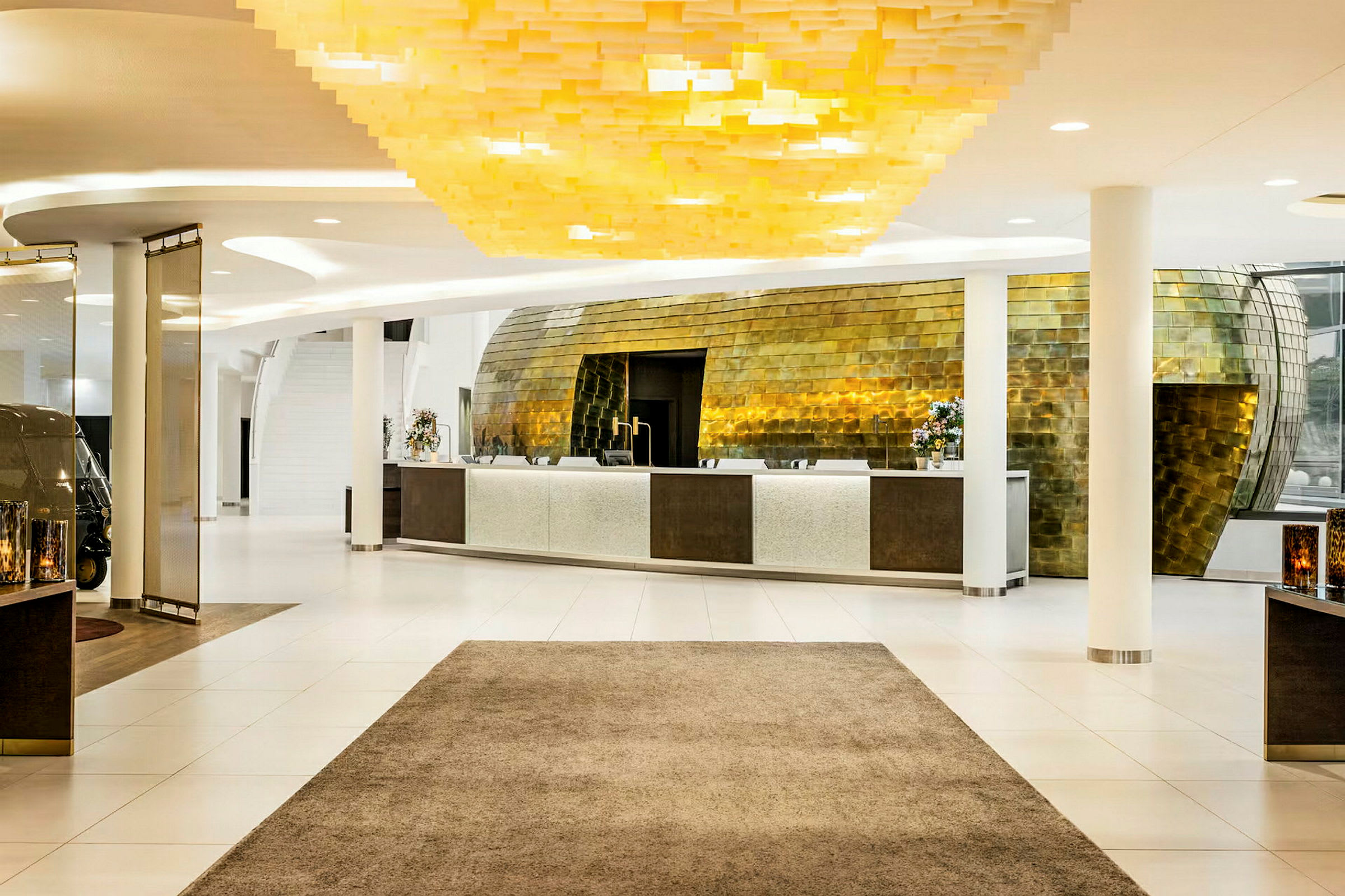 Reception i en modern hotellobby med ett stilfullt gyllene inre och ljus inredning. (AI-genererad text)