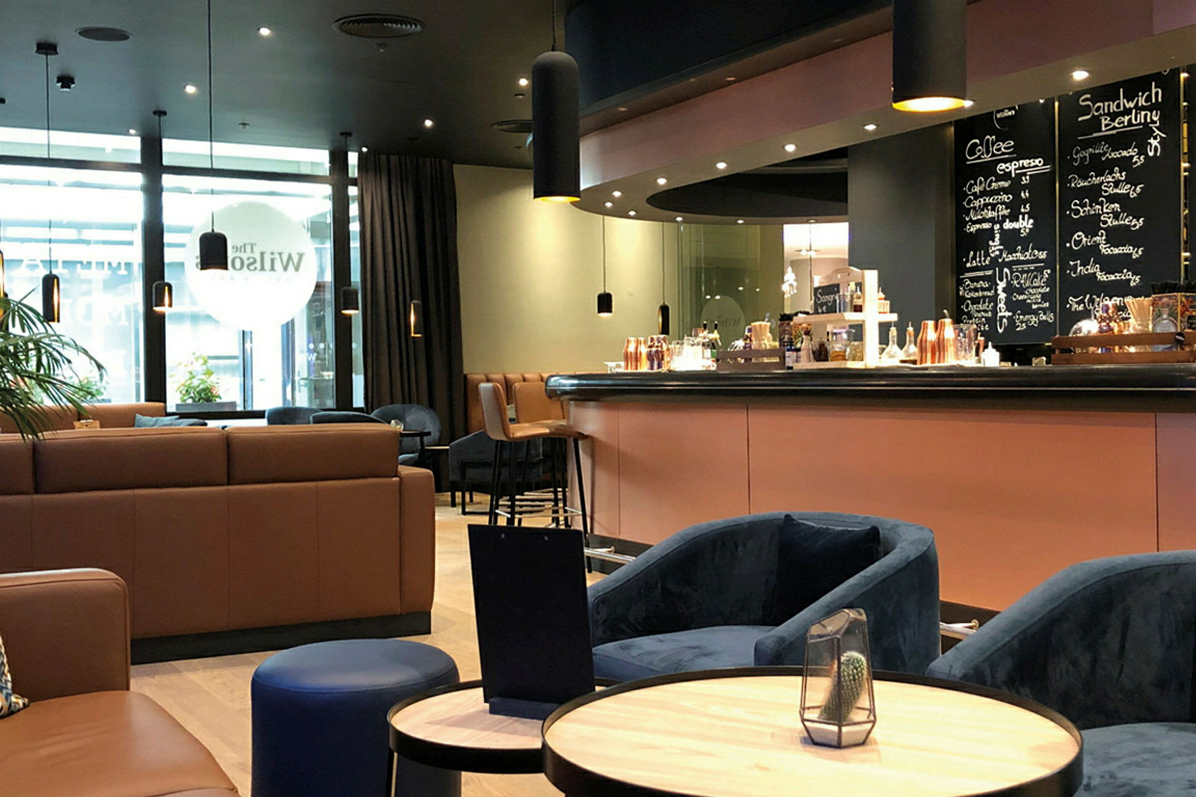 En modern kafémiljö med bekväma sittplatser och en bardisk. (AI-genererad text)