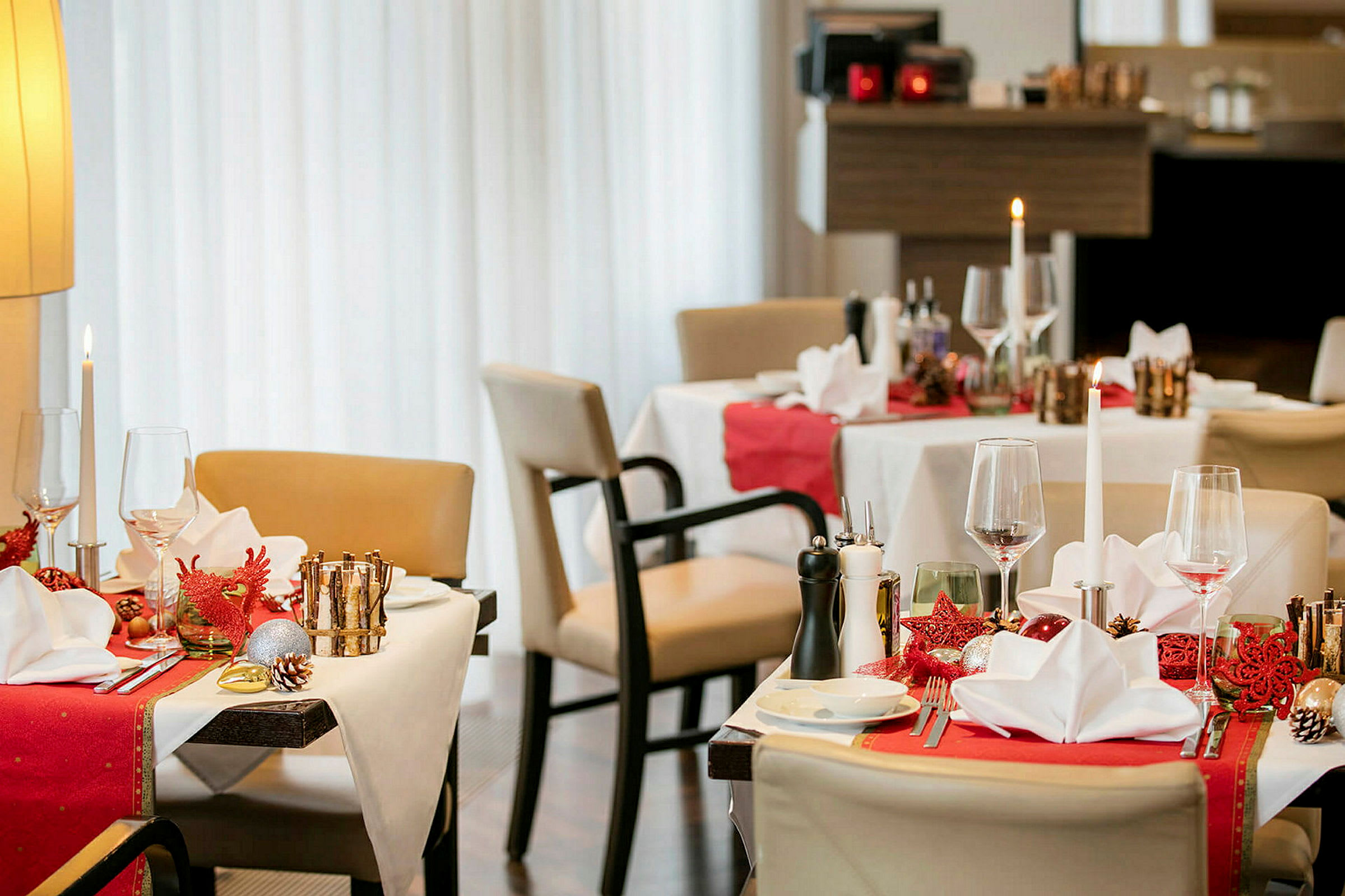 Restaurangbord med juldekorationer, dukade med servetter och glas. (AI-genererad text)