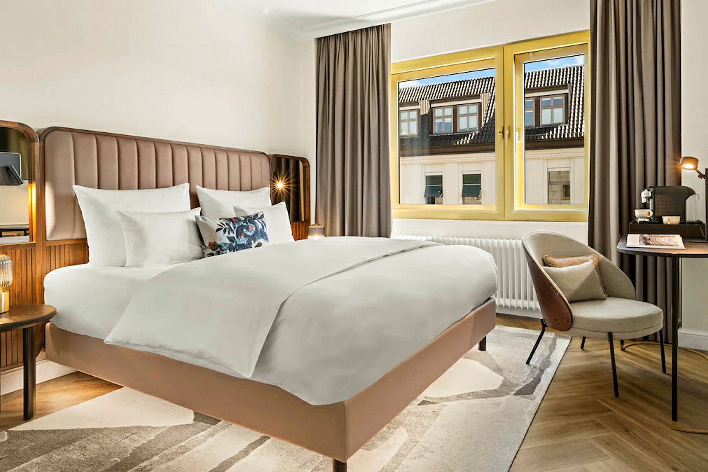 Hotellrum med stor säng, fönster med utsikt och skrivbord. (AI-genererad text)