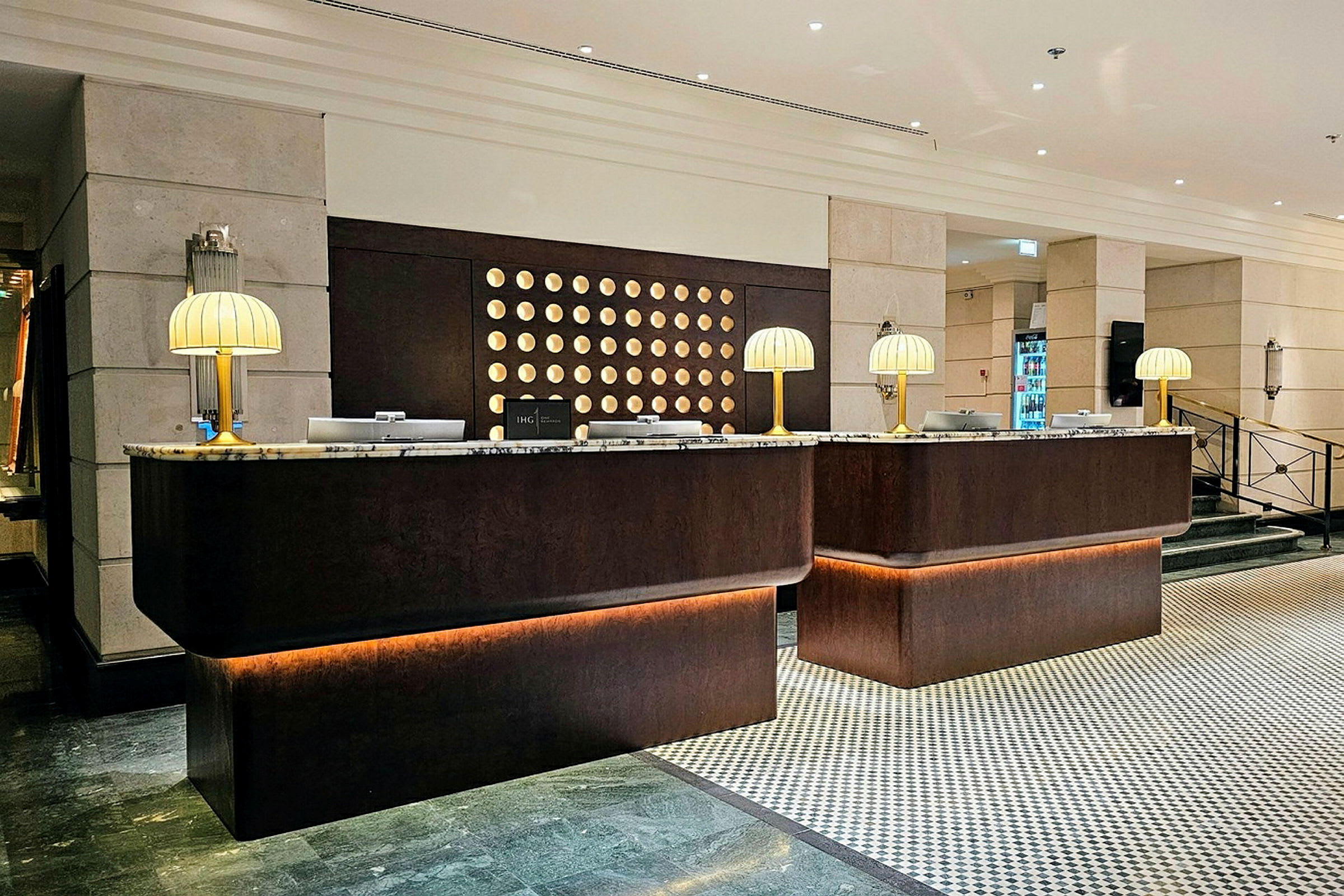En receptionsdisk i en hotellobby, med marmorskivor och bordslampor. (AI-genererad text)